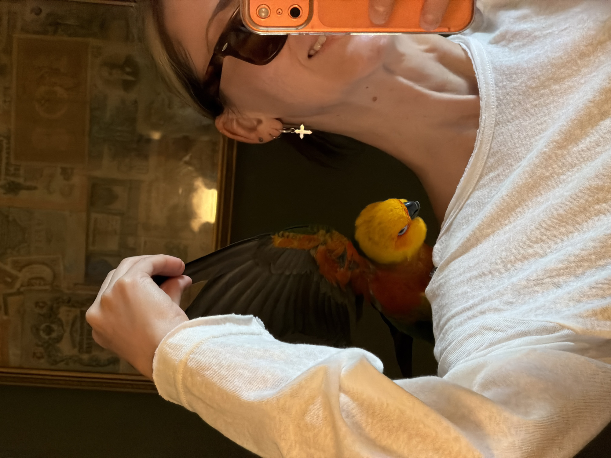 Mirror selfie with a colorful parrot perched on shoulder