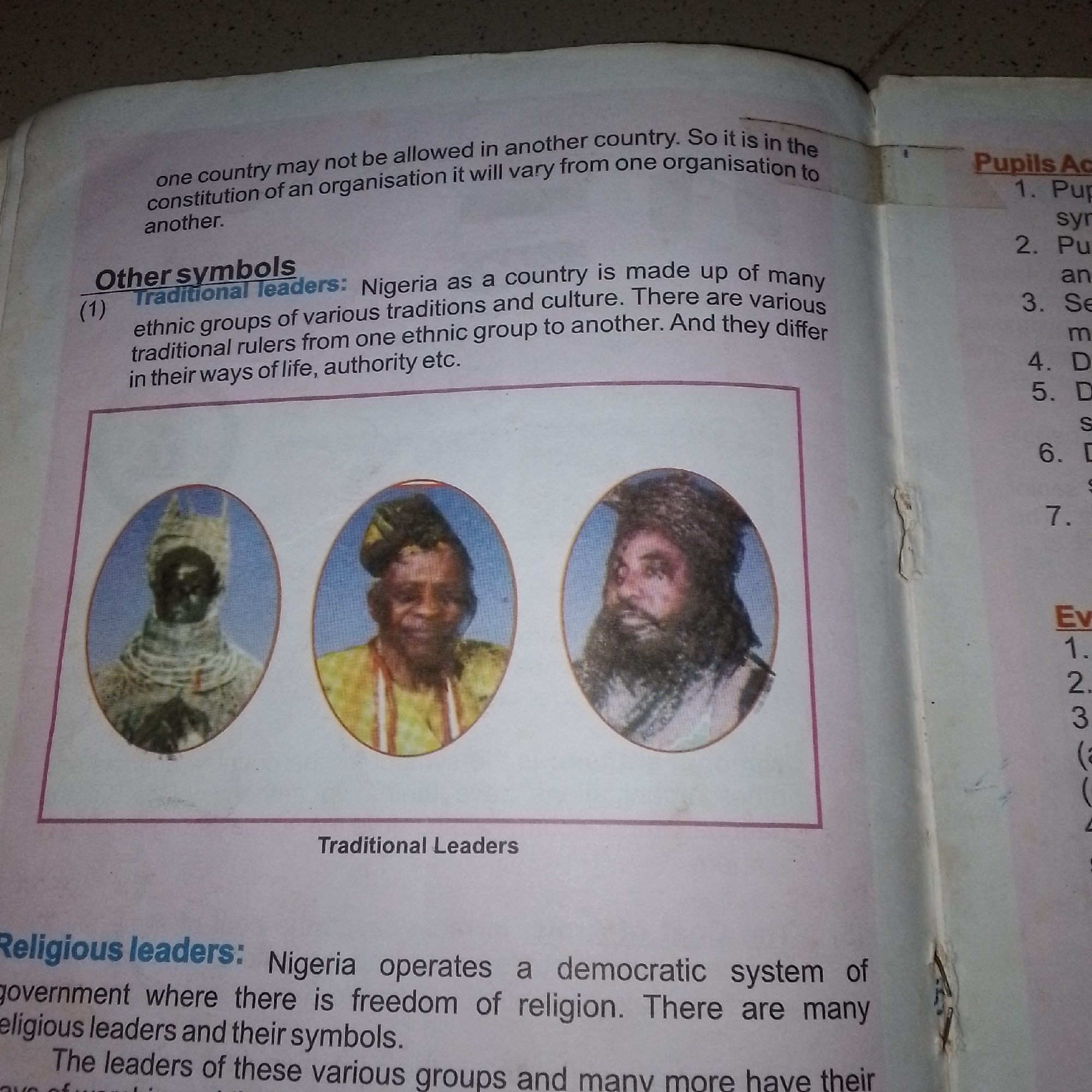 Nigerian civics textbook pages photographed alongside rural surroundings