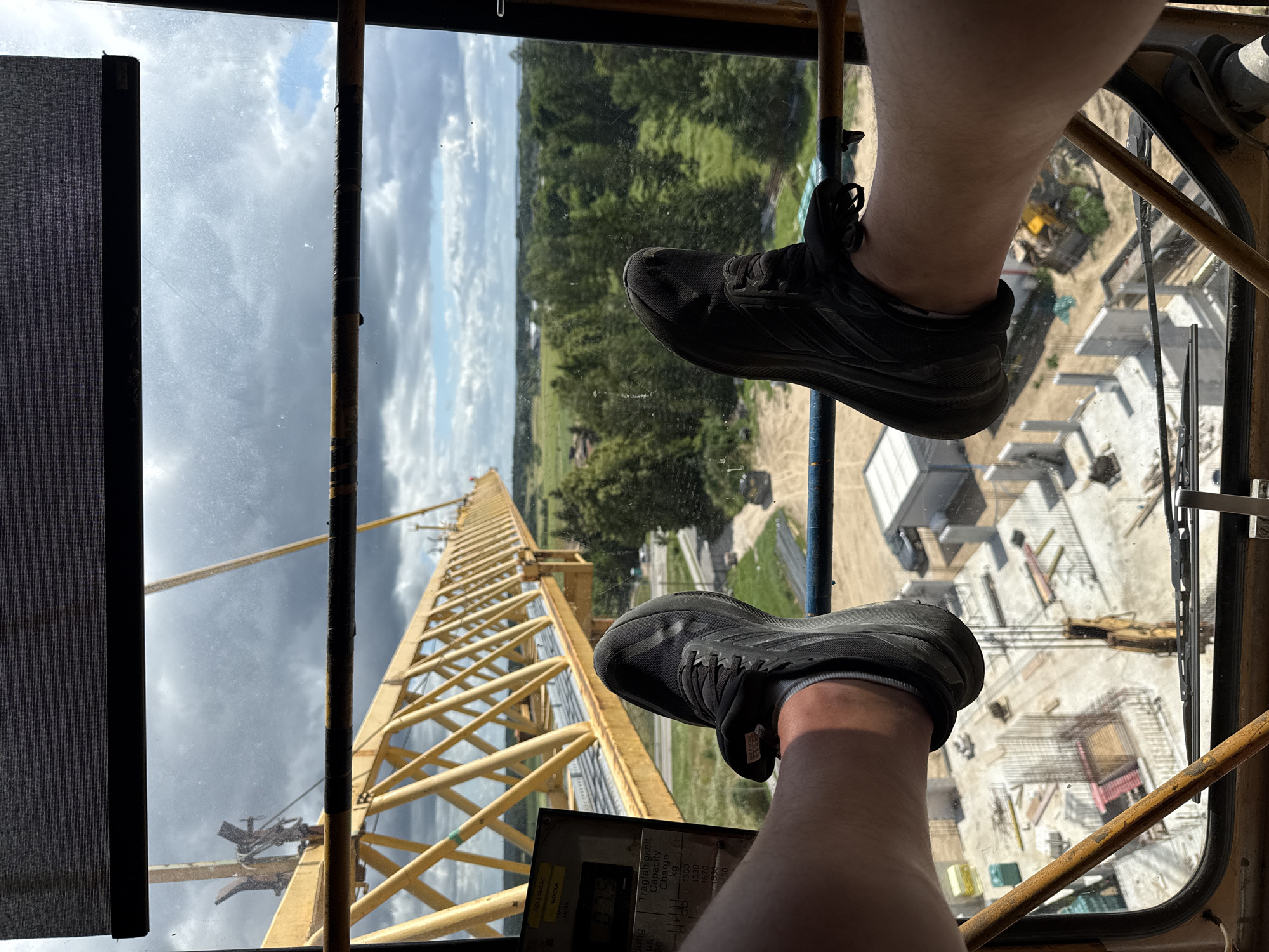 Crane work underway in Mikołajki, Poland, overlooking lake and fields