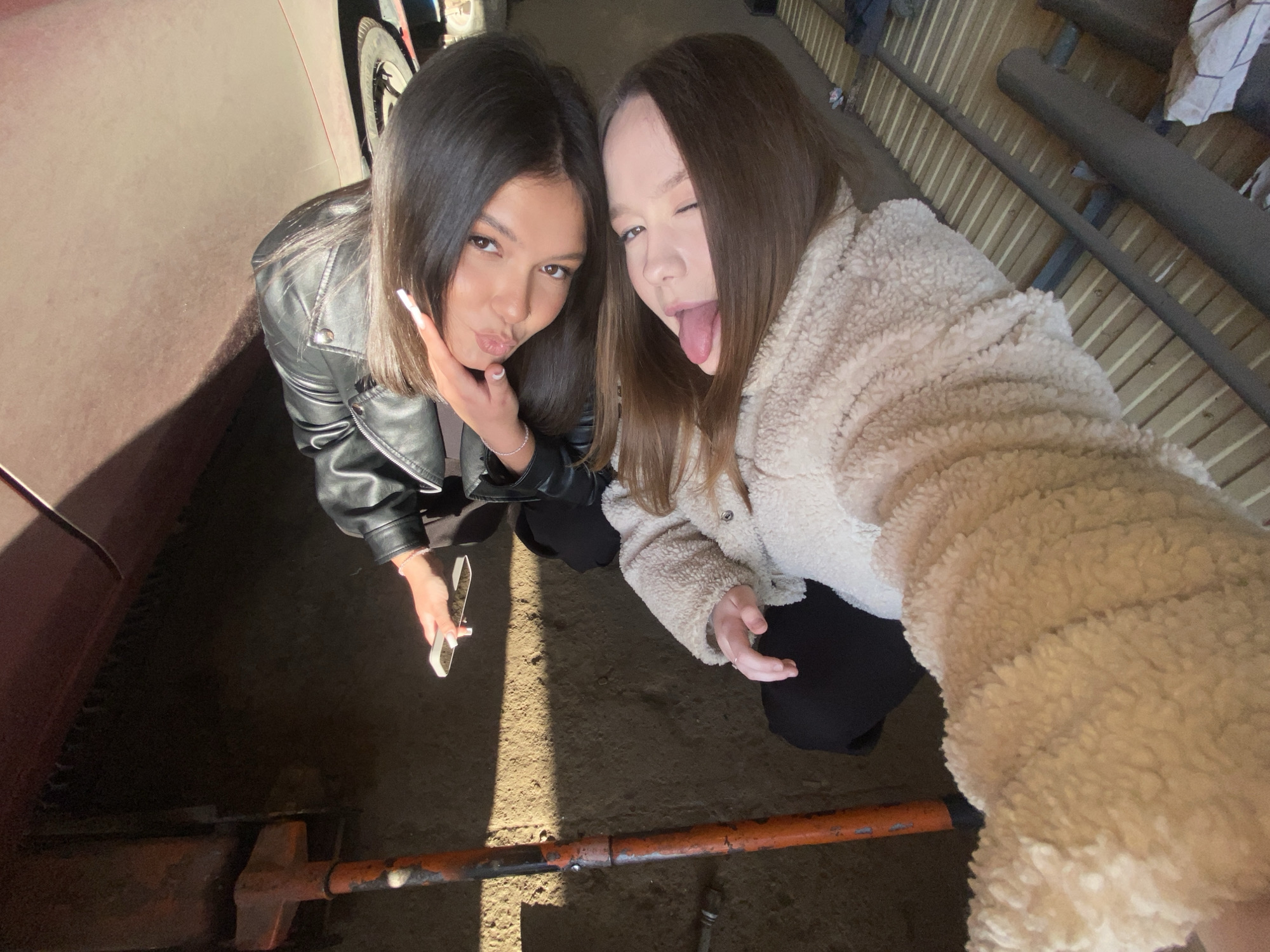 Women take selfies at auto garage during car repair