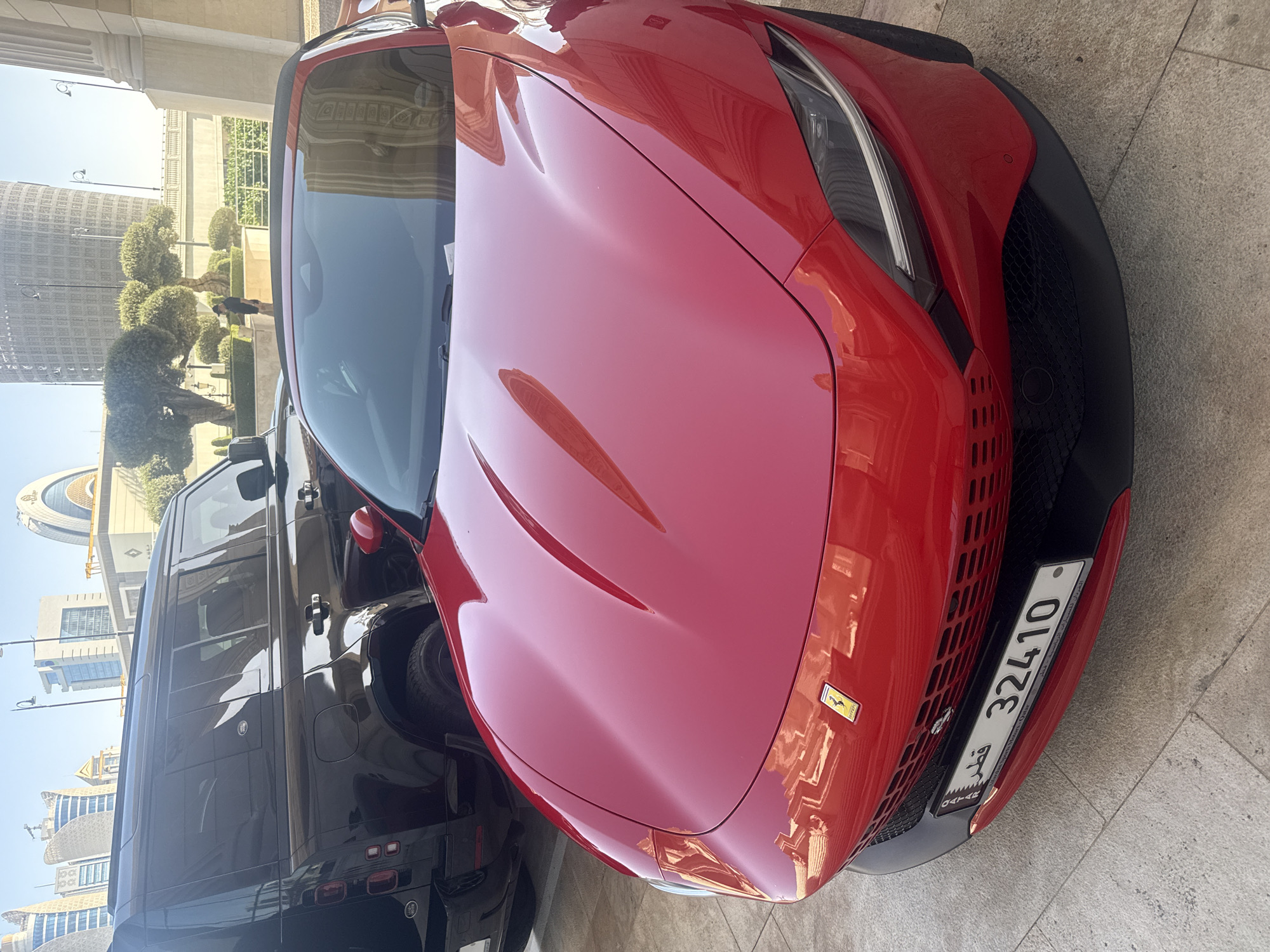 Red Ferrari spotted parked with SUV in Lusail