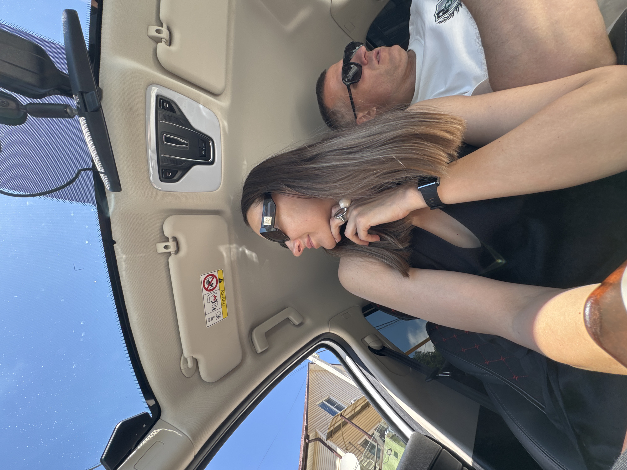 Woman takes selfies in car during sunny day in Sochi