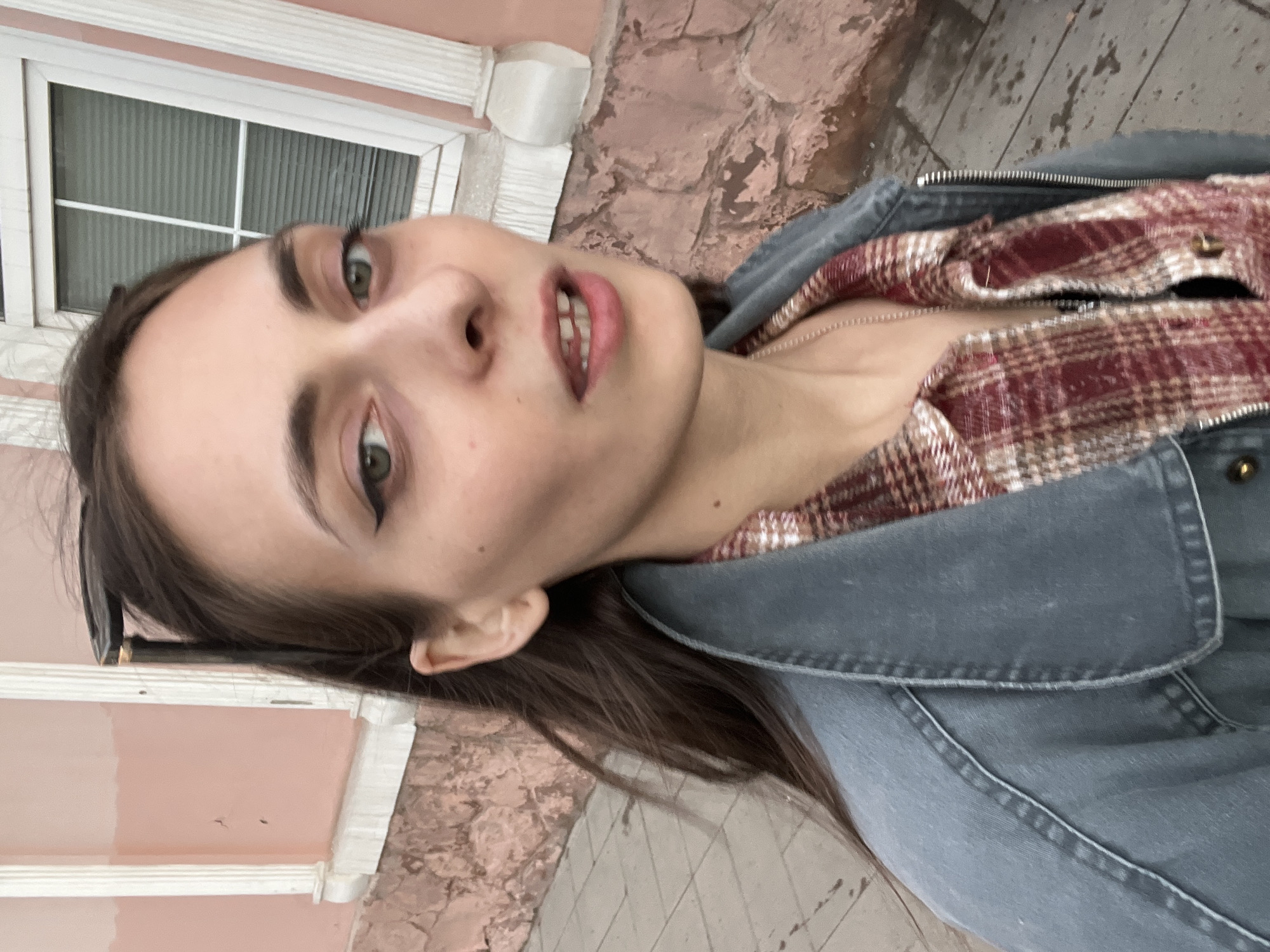 Woman takes selfie near pink building in Krasnoyarsk