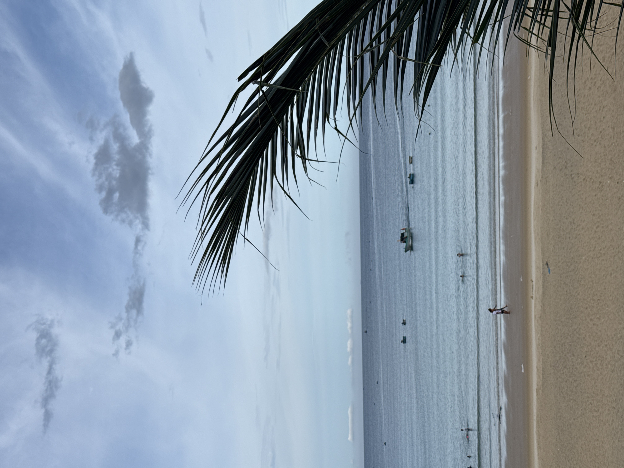 Quiet beach morning, calm surf, people strolling the shoreline