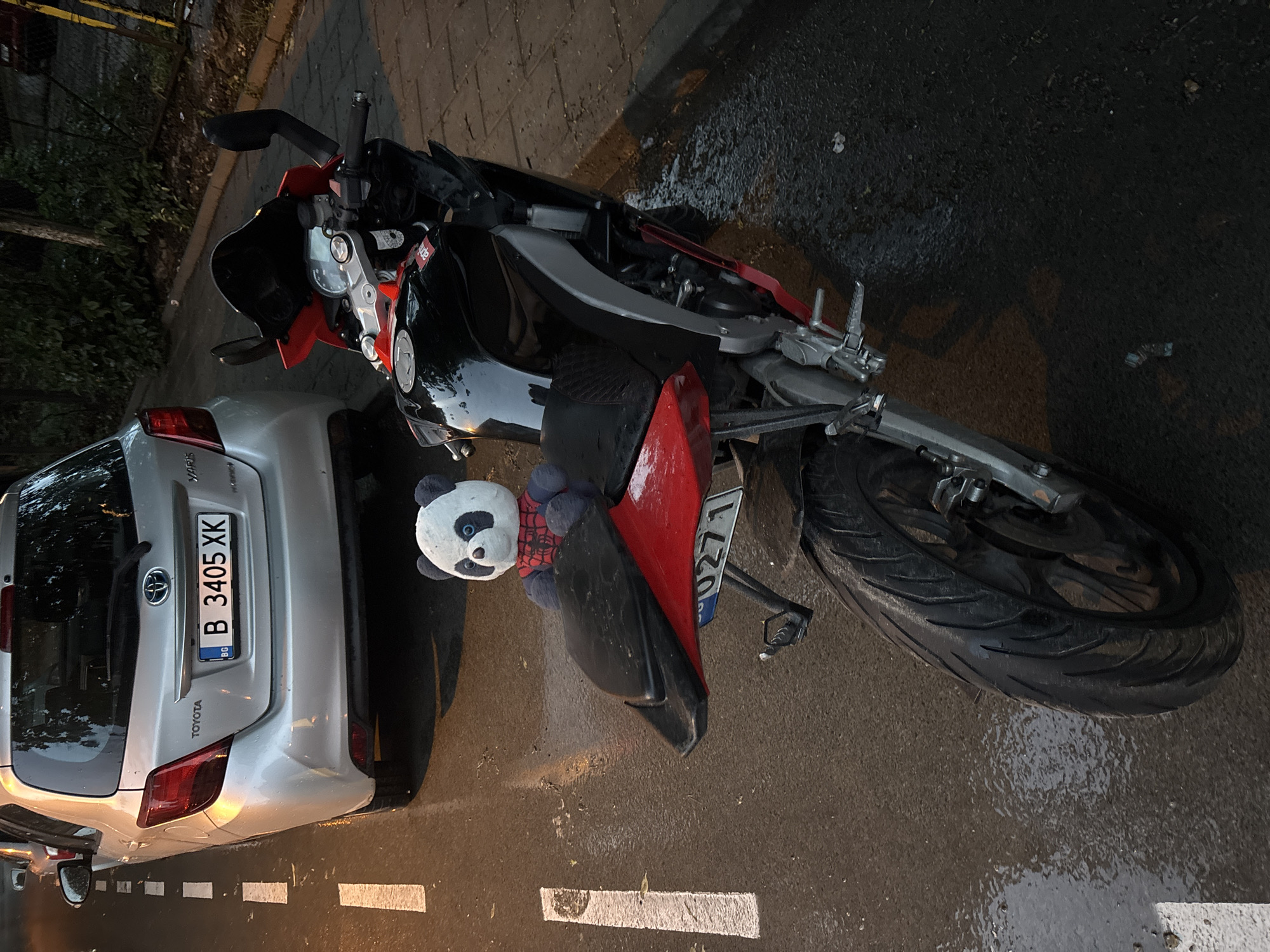 Motorcycle and car parked on wet street in Varna