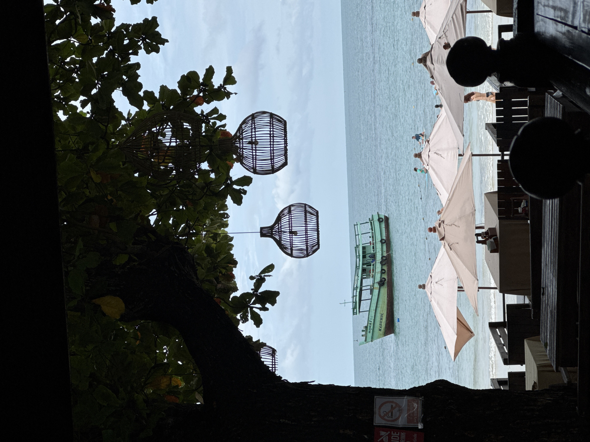 Shaded beachfront restaurant overlooks calm ocean at Ao Phai
