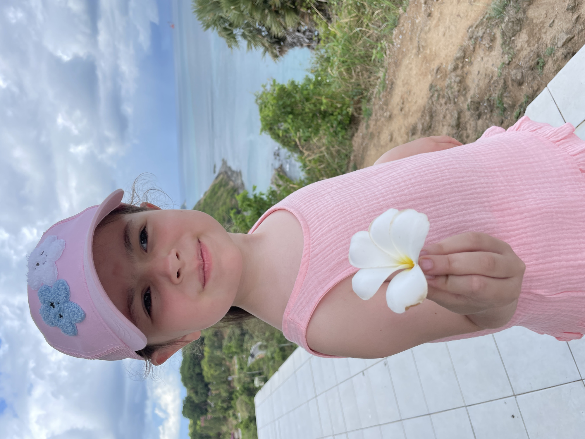 Girl with flower poses at Thailand's scenic Promthep Cape
