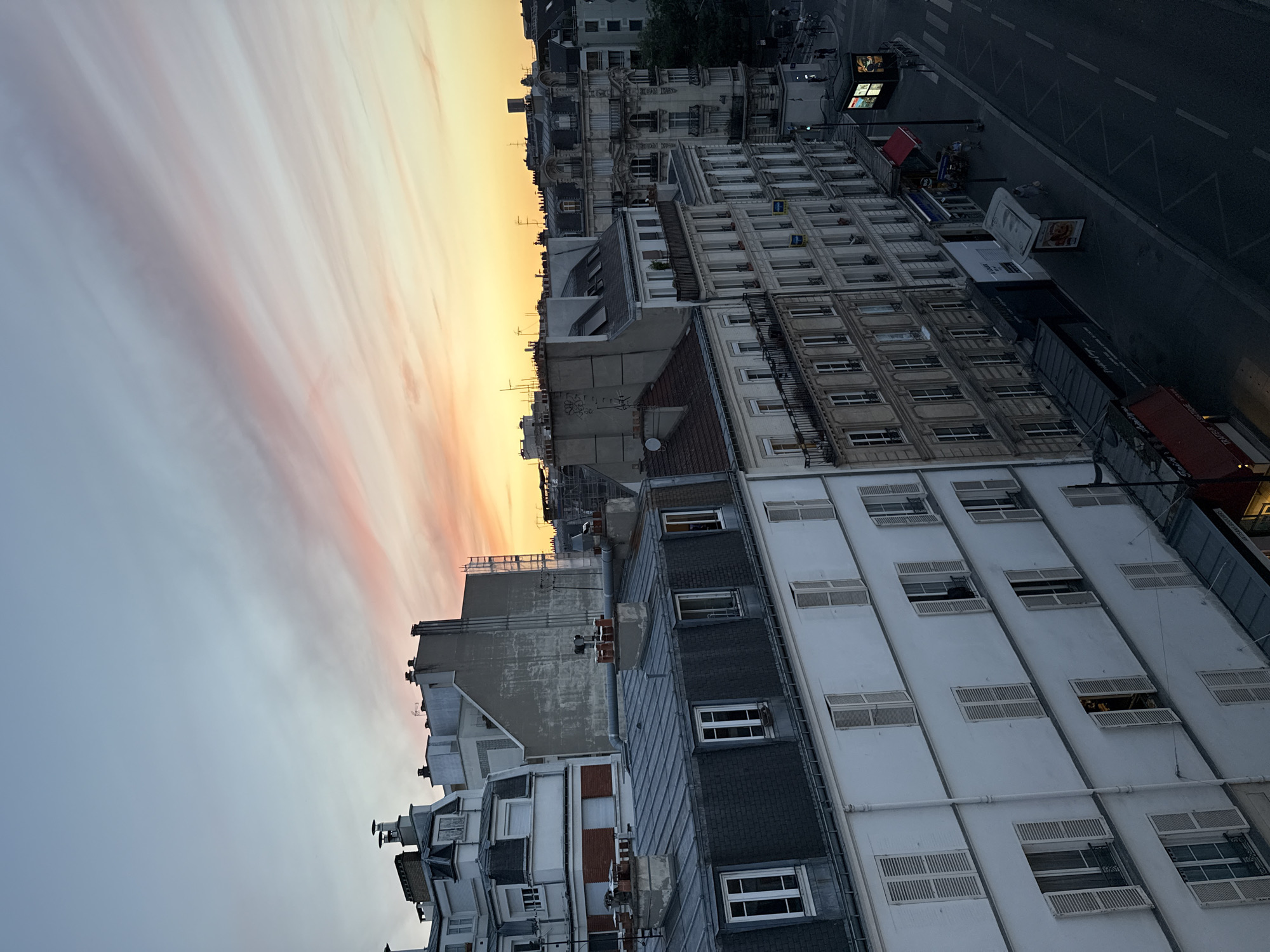 Rooftop-level Paris at golden hour, cafes and classic architecture