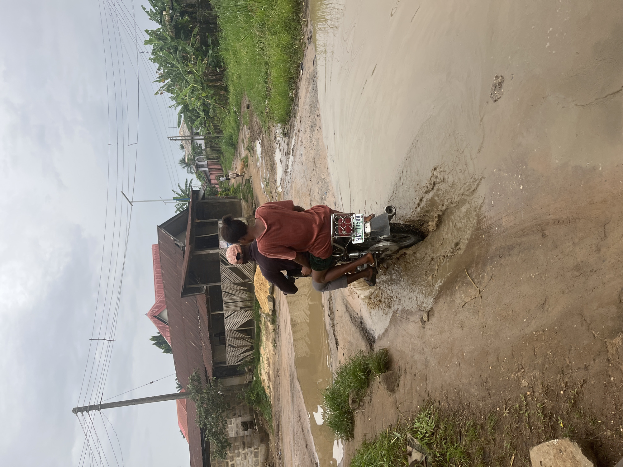 Motorcyclists navigate flooded roads in Ikot Ekpene, Nigeria