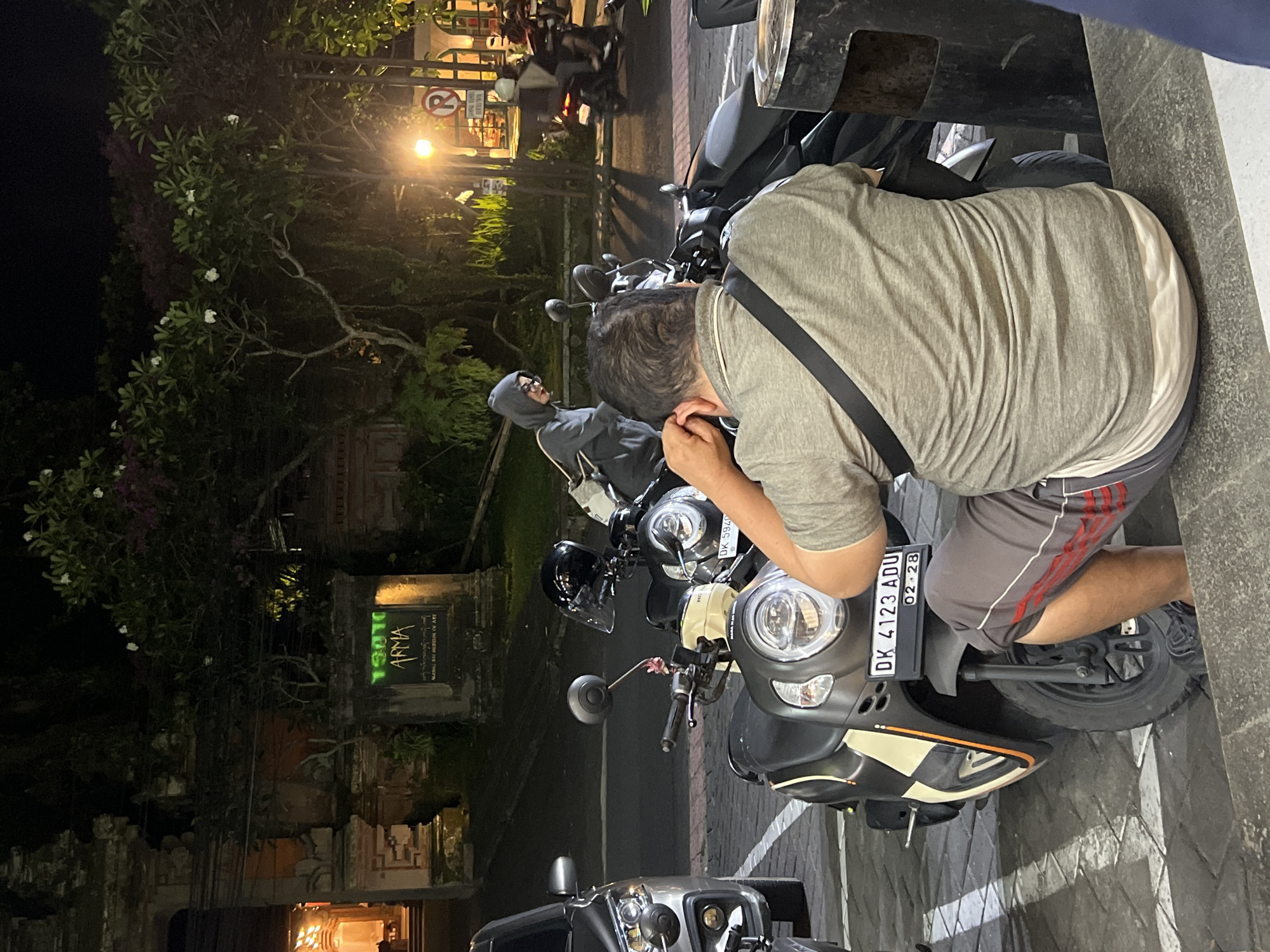 Motor scooter parked on Ubud street at night
