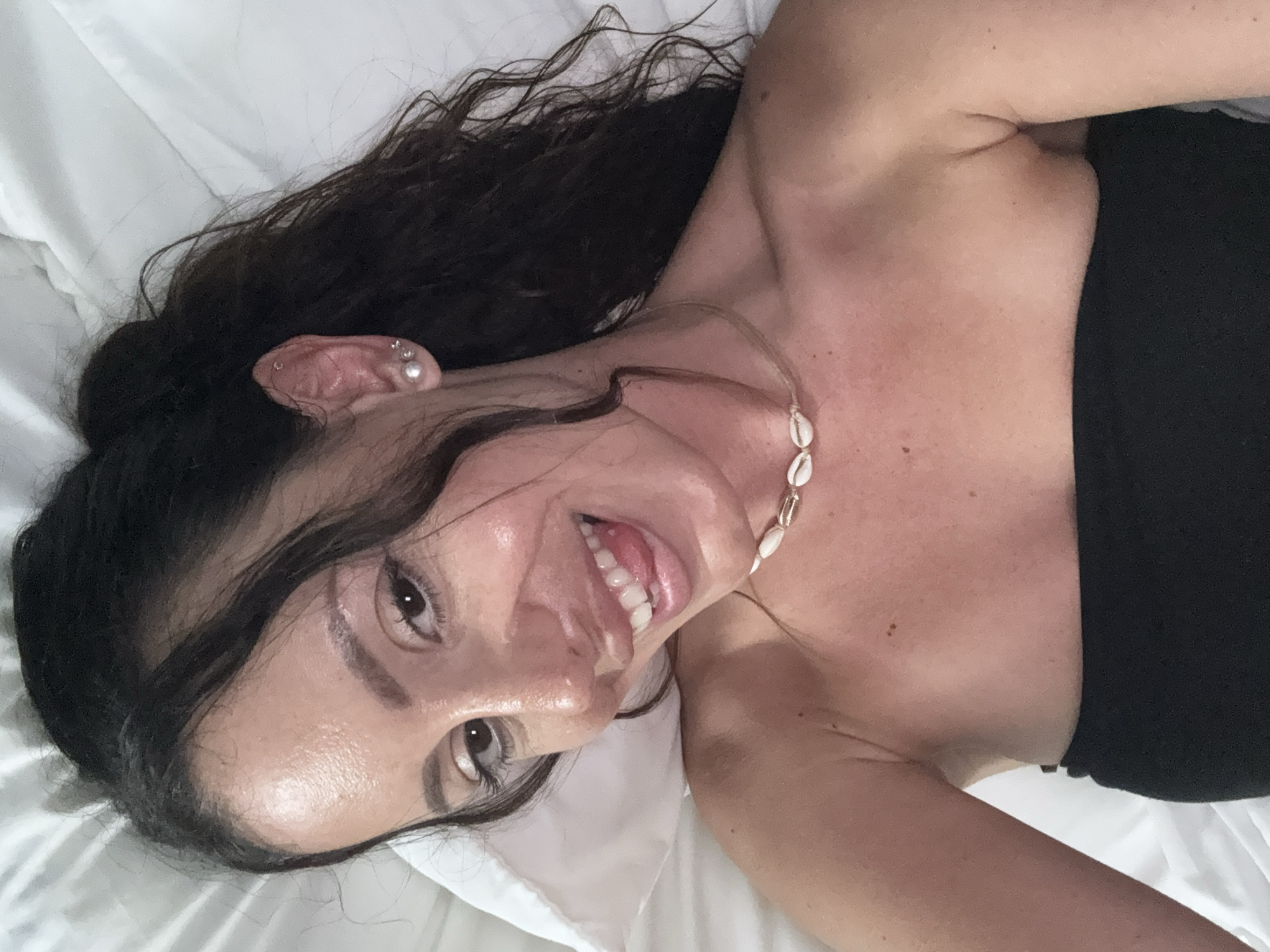 Woman in black top rests on white surface in Sarasota