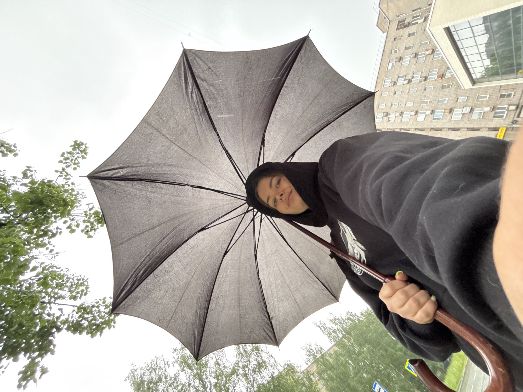 Woman with umbrella photographed during early morning rain in Izhevsk