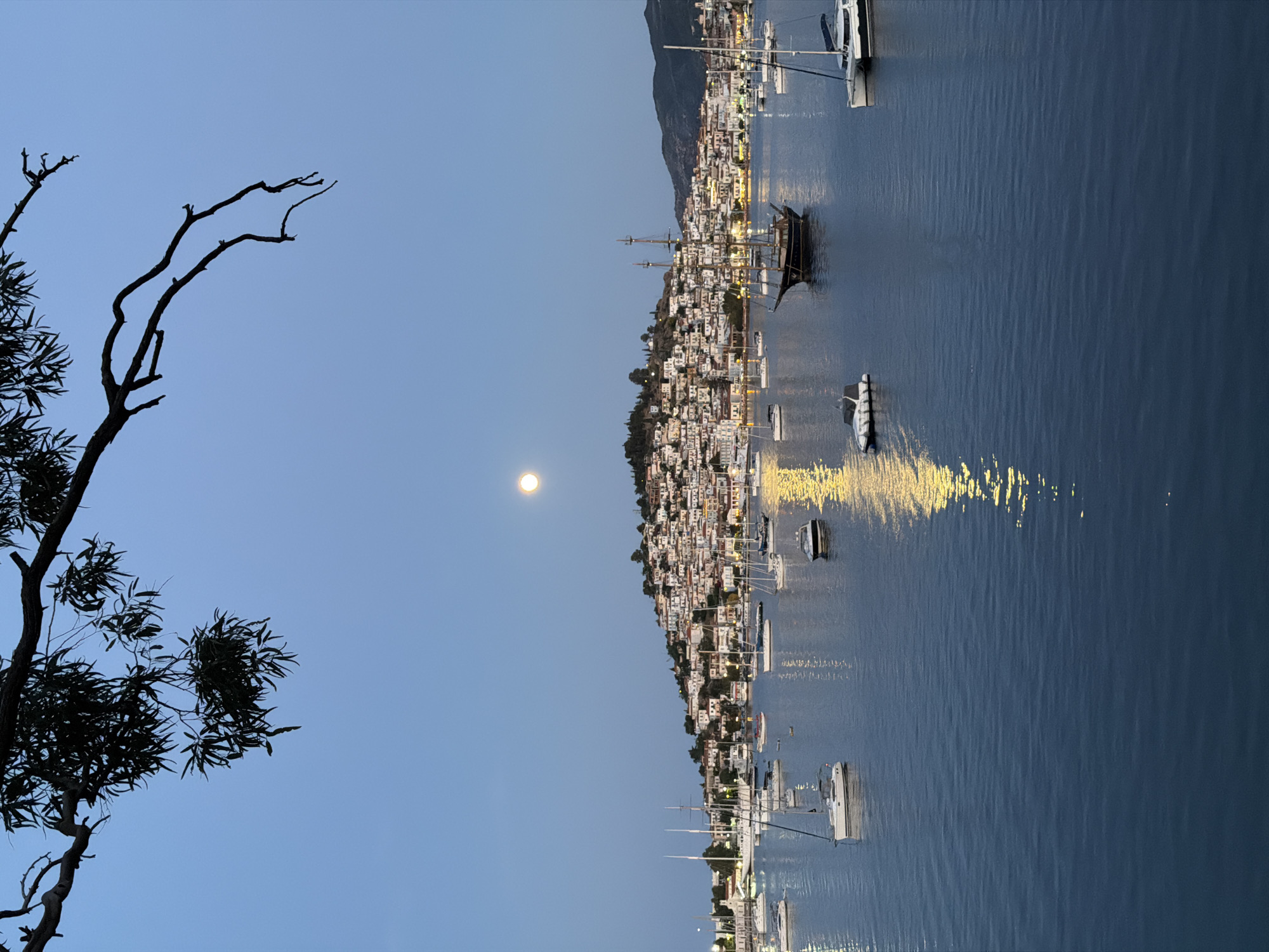 Evening scenes captured across Poros, Greece include moonrise and harbor