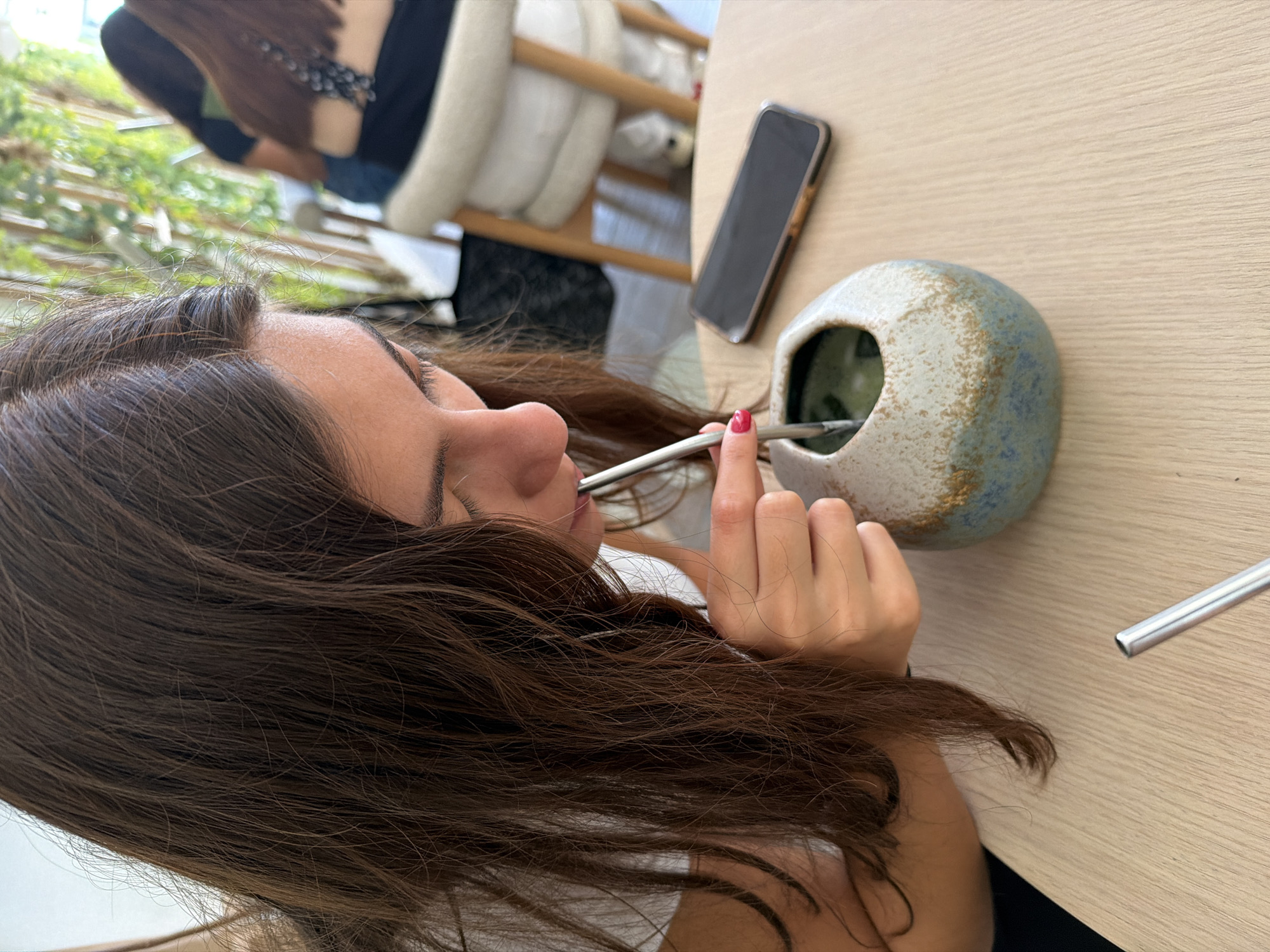 Woman enjoys traditional mate and matcha drinks at Puebla cafe