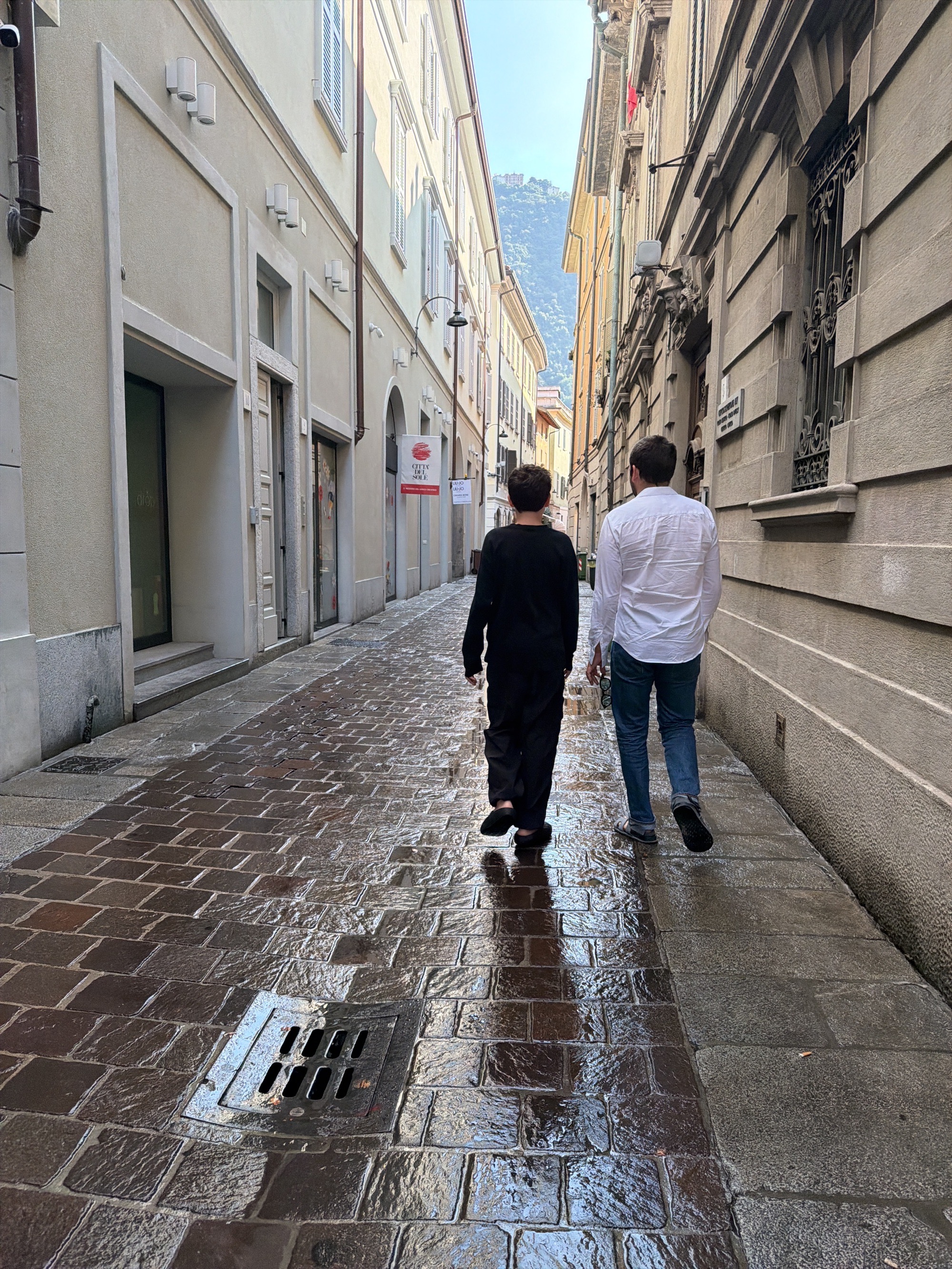 Morning stroll through wet cobblestone streets in Como, Italy