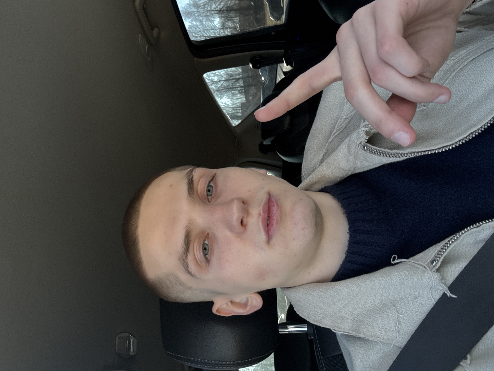 Young man makes peace sign in car in Riga
