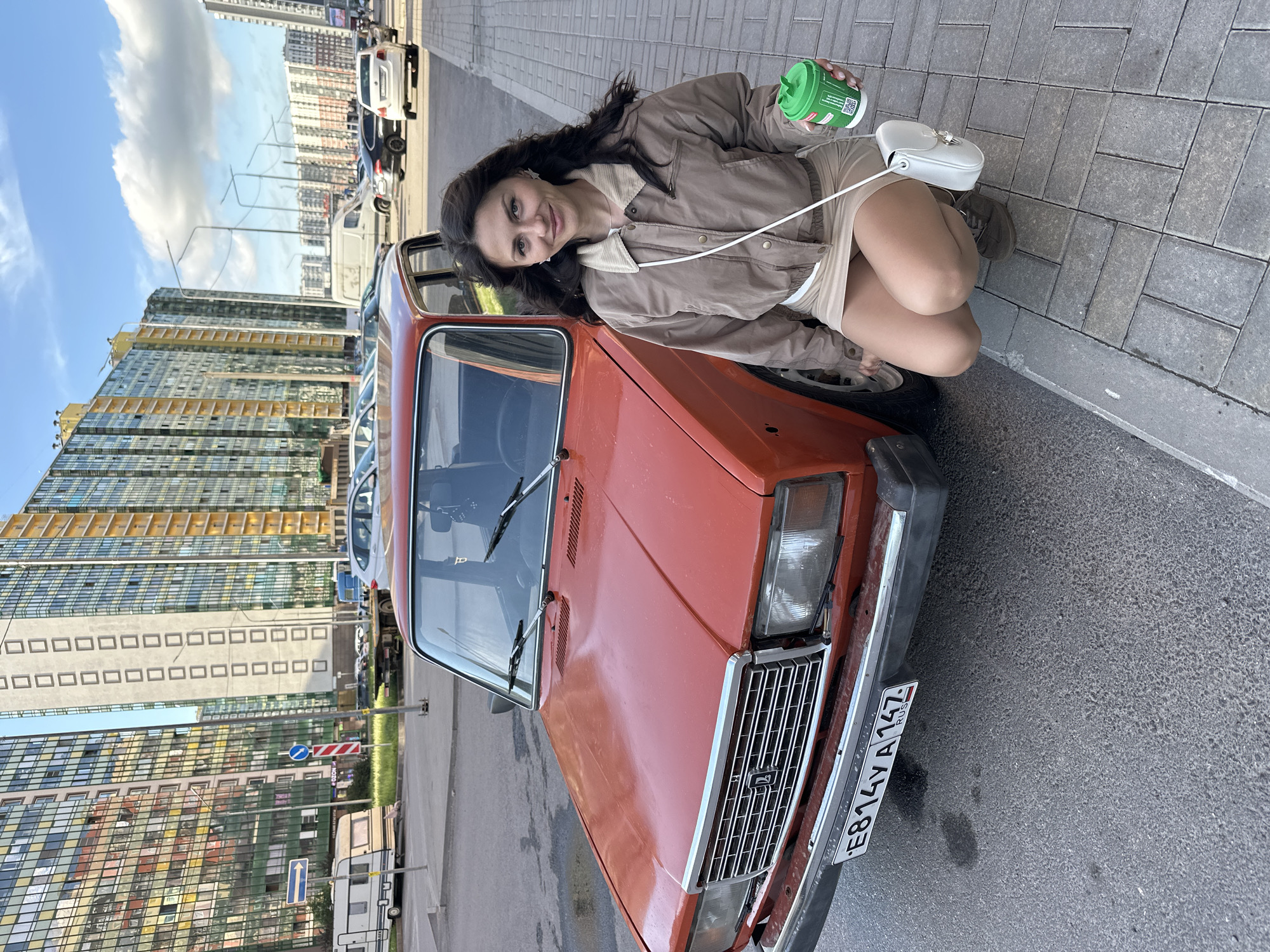 Posing beside a vintage orange car on a Murino street