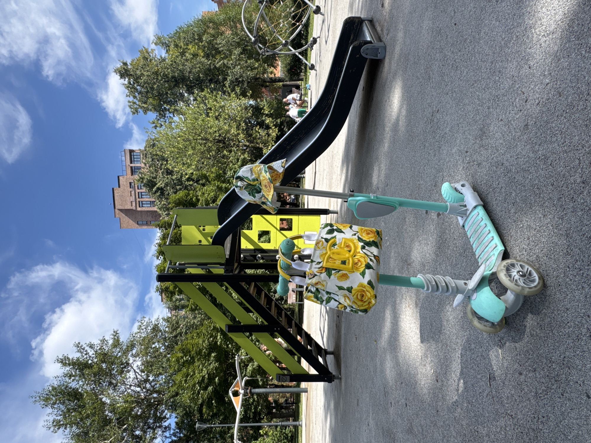 DG floral tote hangs from a parked three-wheeled scooter