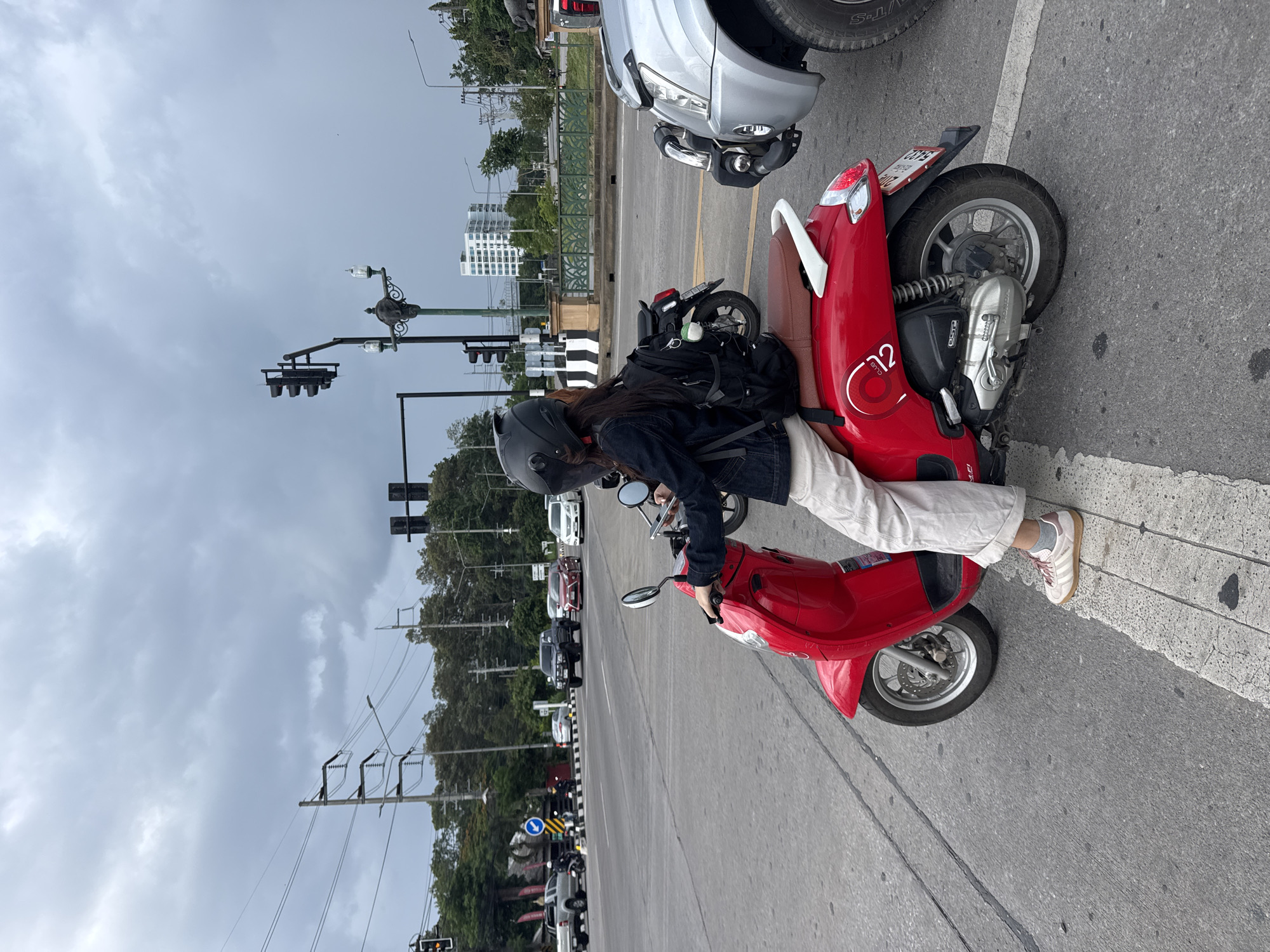 Red scooter paused at a traffic light in Chang Phueak