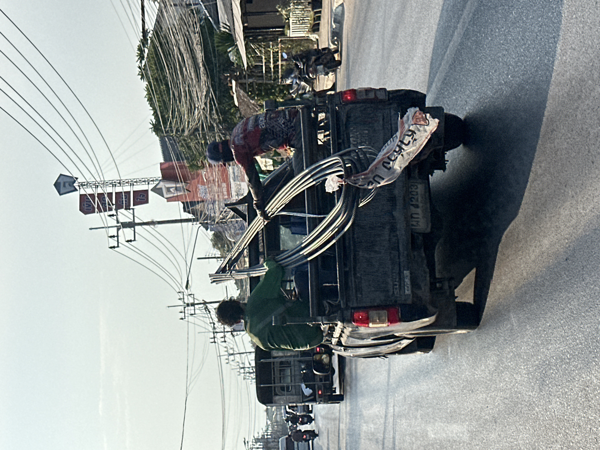 Two men handle materials from pickup truck in Thailand