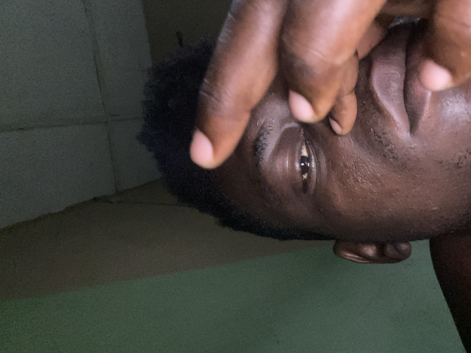 Person covers face with hand in close-up photograph