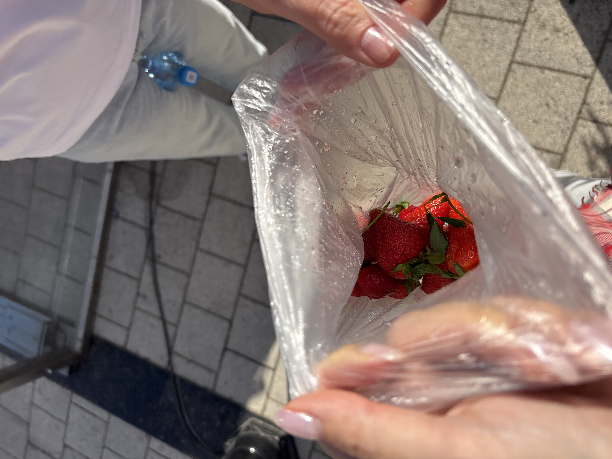 Woman buys strawberries on Krasnoyarsk sidewalk during morning outing