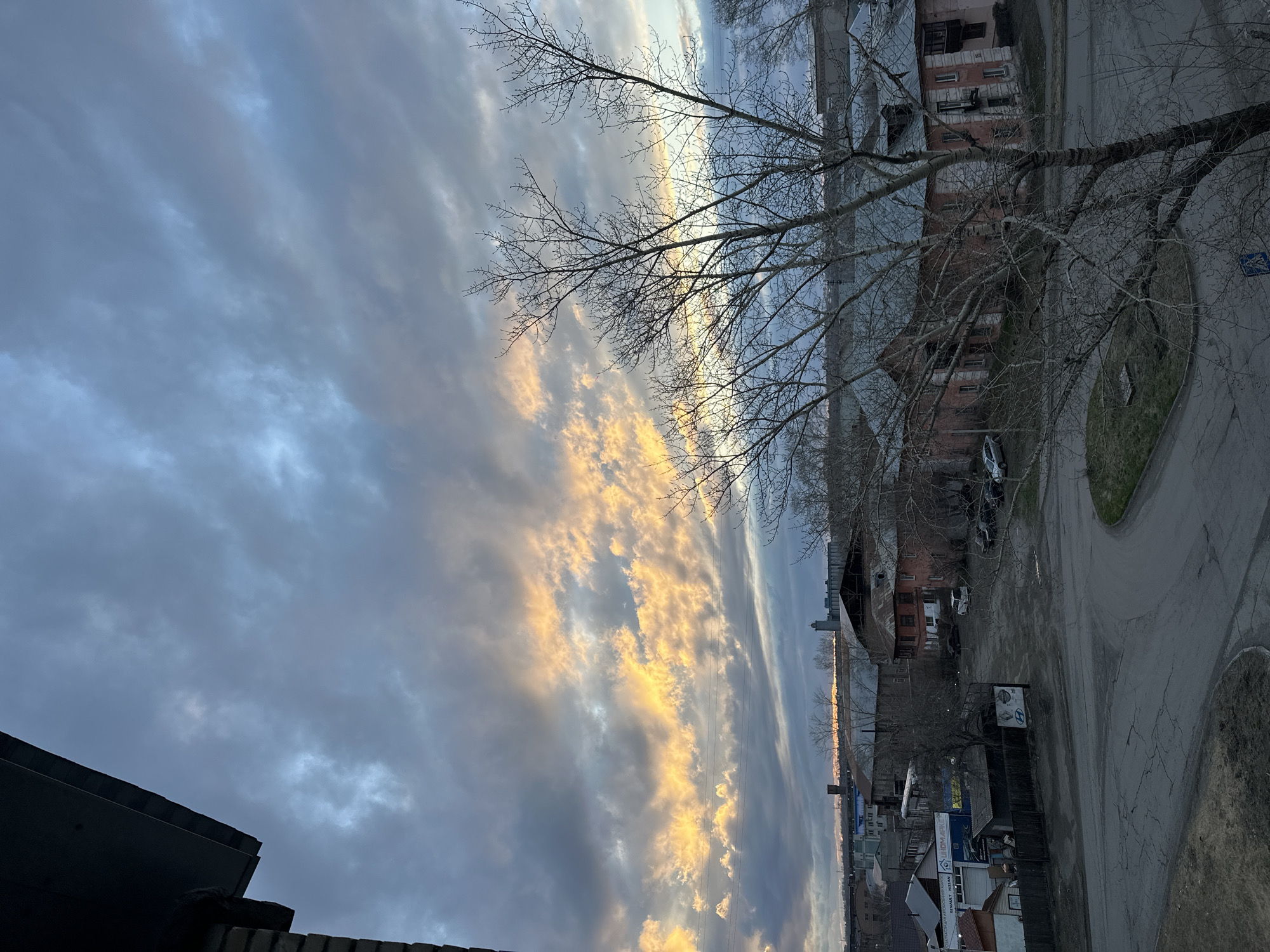 Dramatic sunset illuminates urban skyline with golden clouds