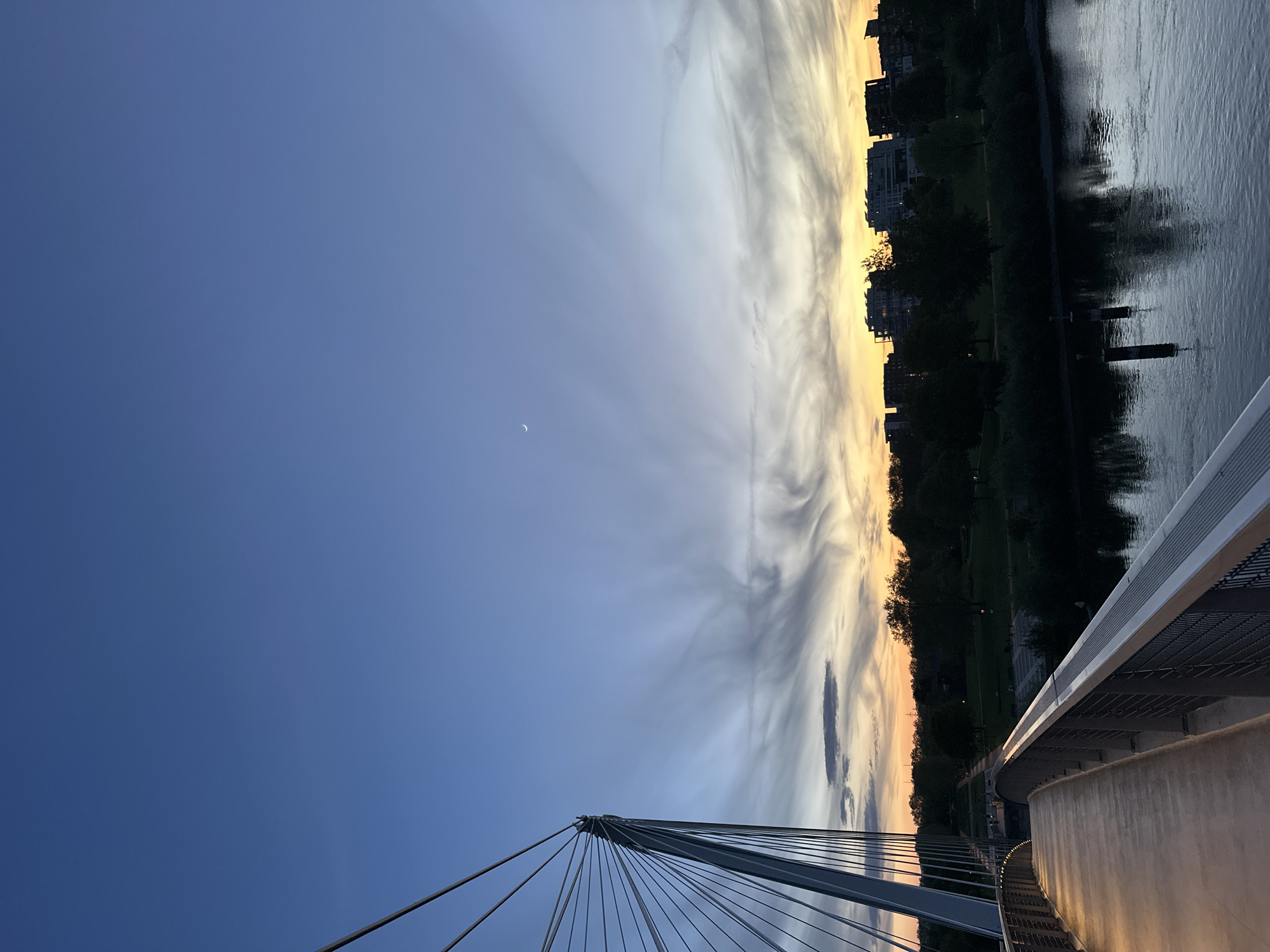 Dusk settles over Strasbourg's Citadelle bridge with crescent moon
