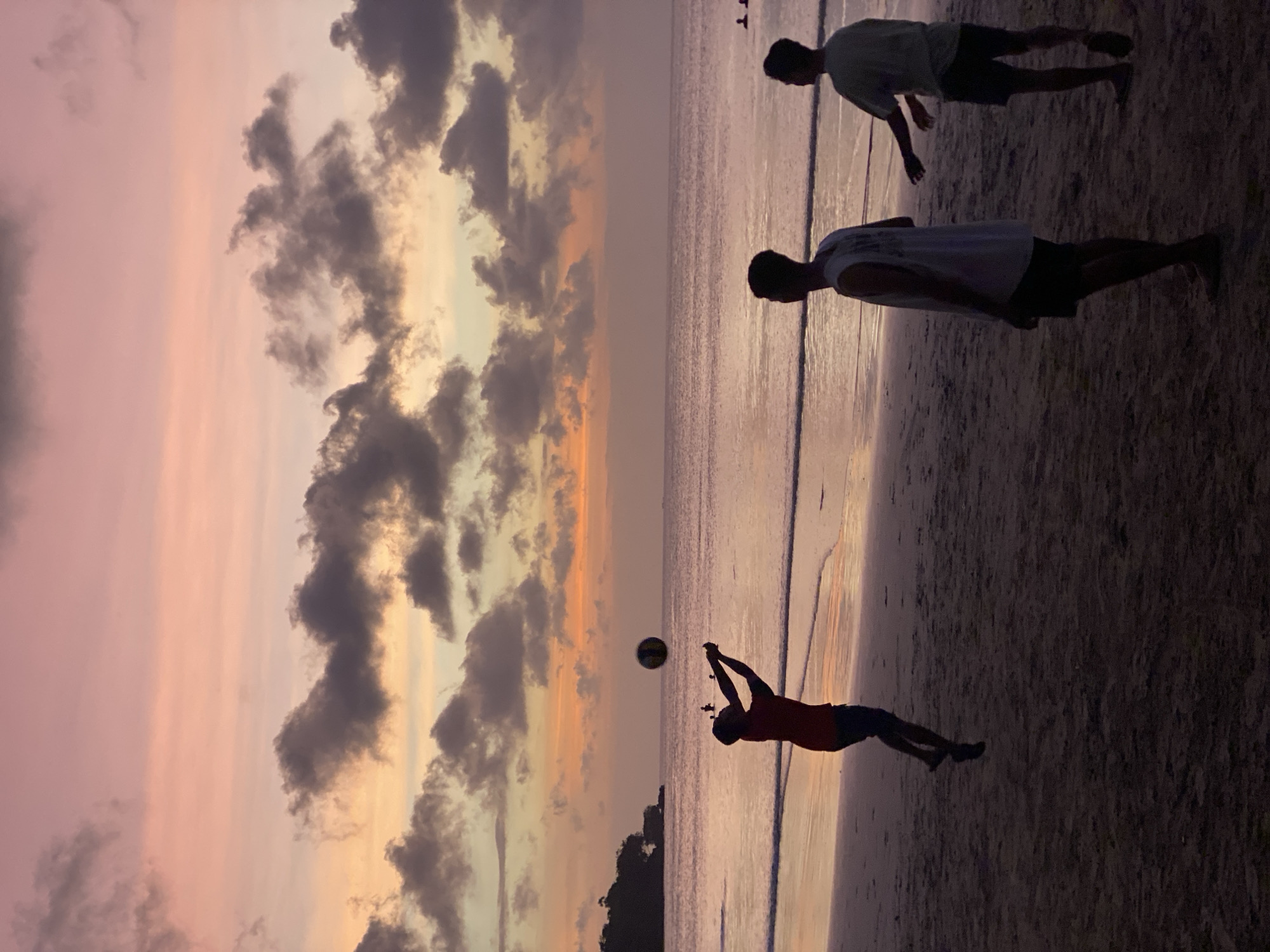 Dusk gathering on a Kuta Selatan beach under a colorful sky