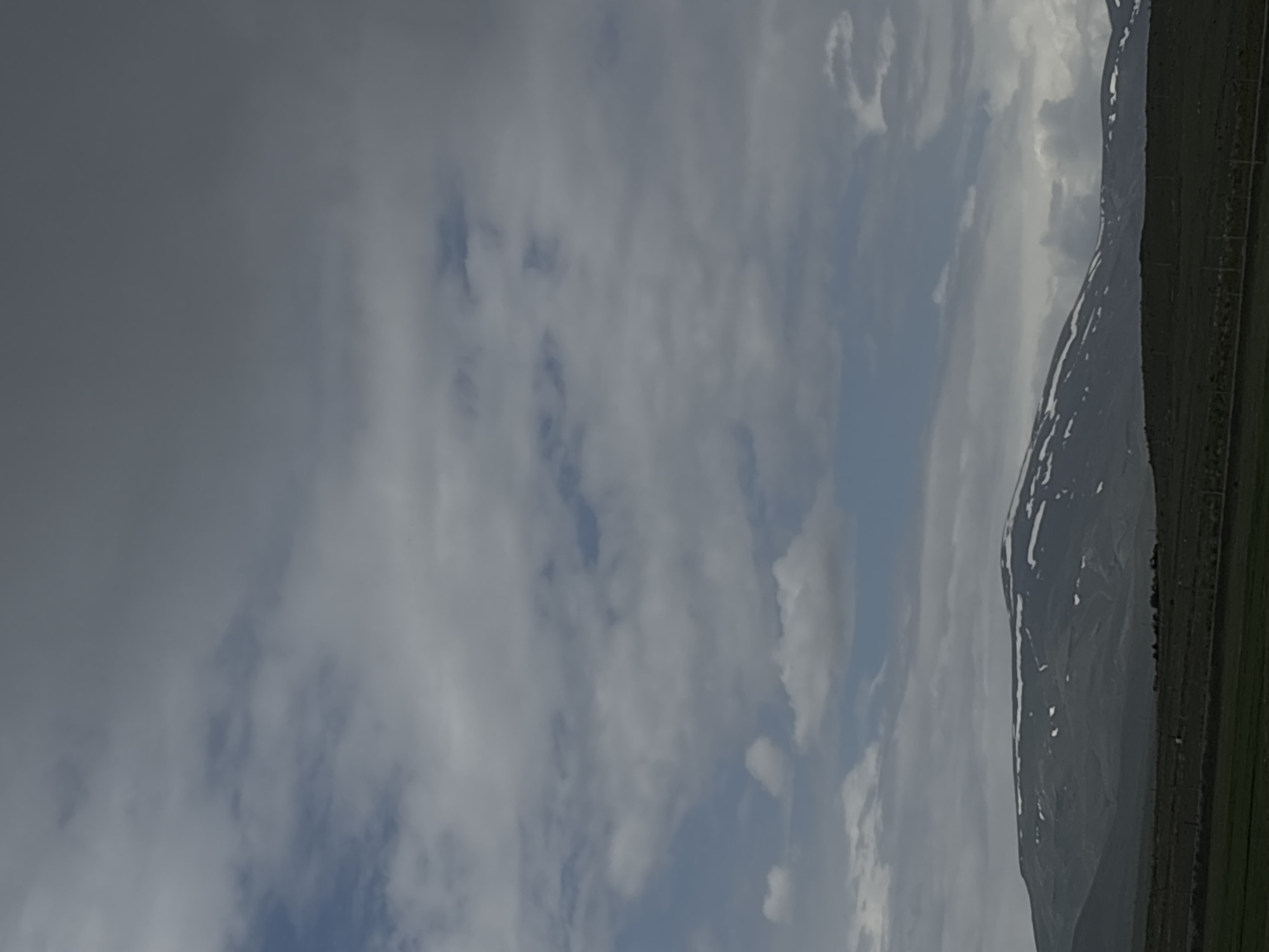 Cloudy skies and snow-capped mountains observed near Tlik, Armenia