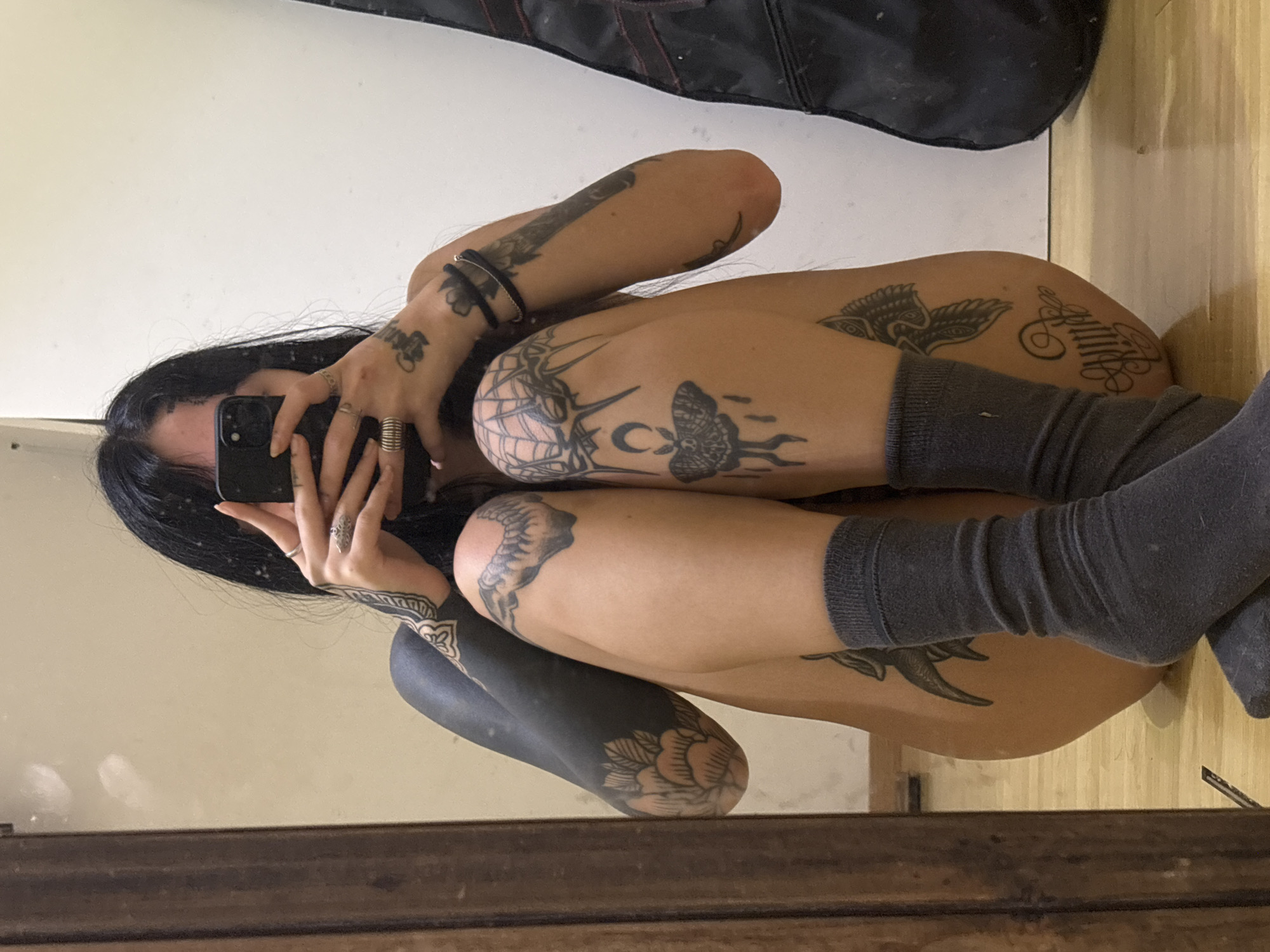 Tattooed person takes mirror selfie in Villa Ballester