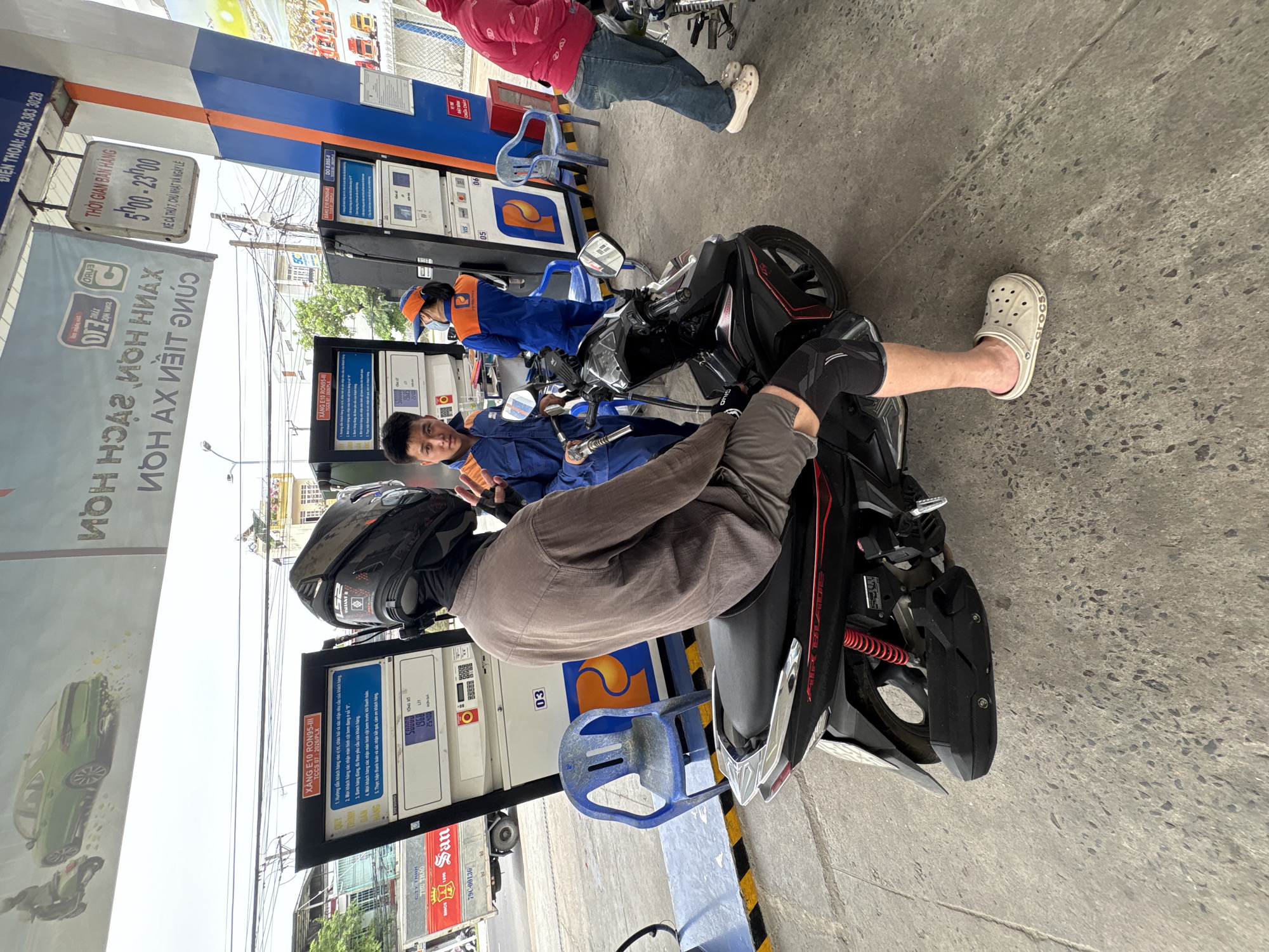 Motorcyclist refuels at Vietnam gas station during morning commute