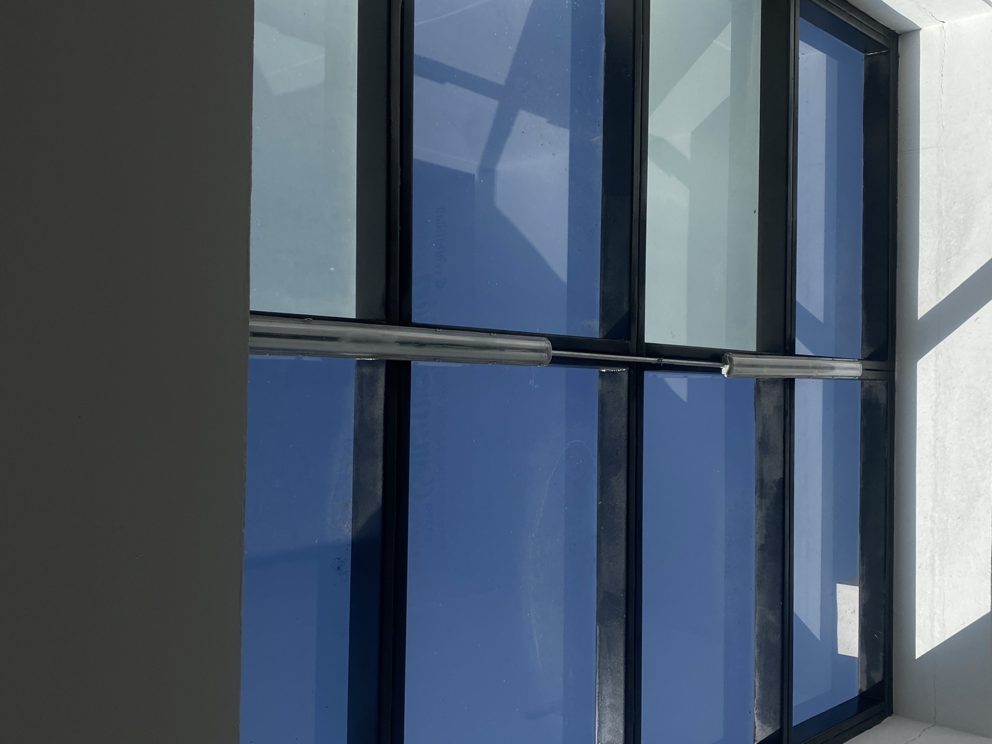 Building windows reflect clear blue sky in architectural photograph