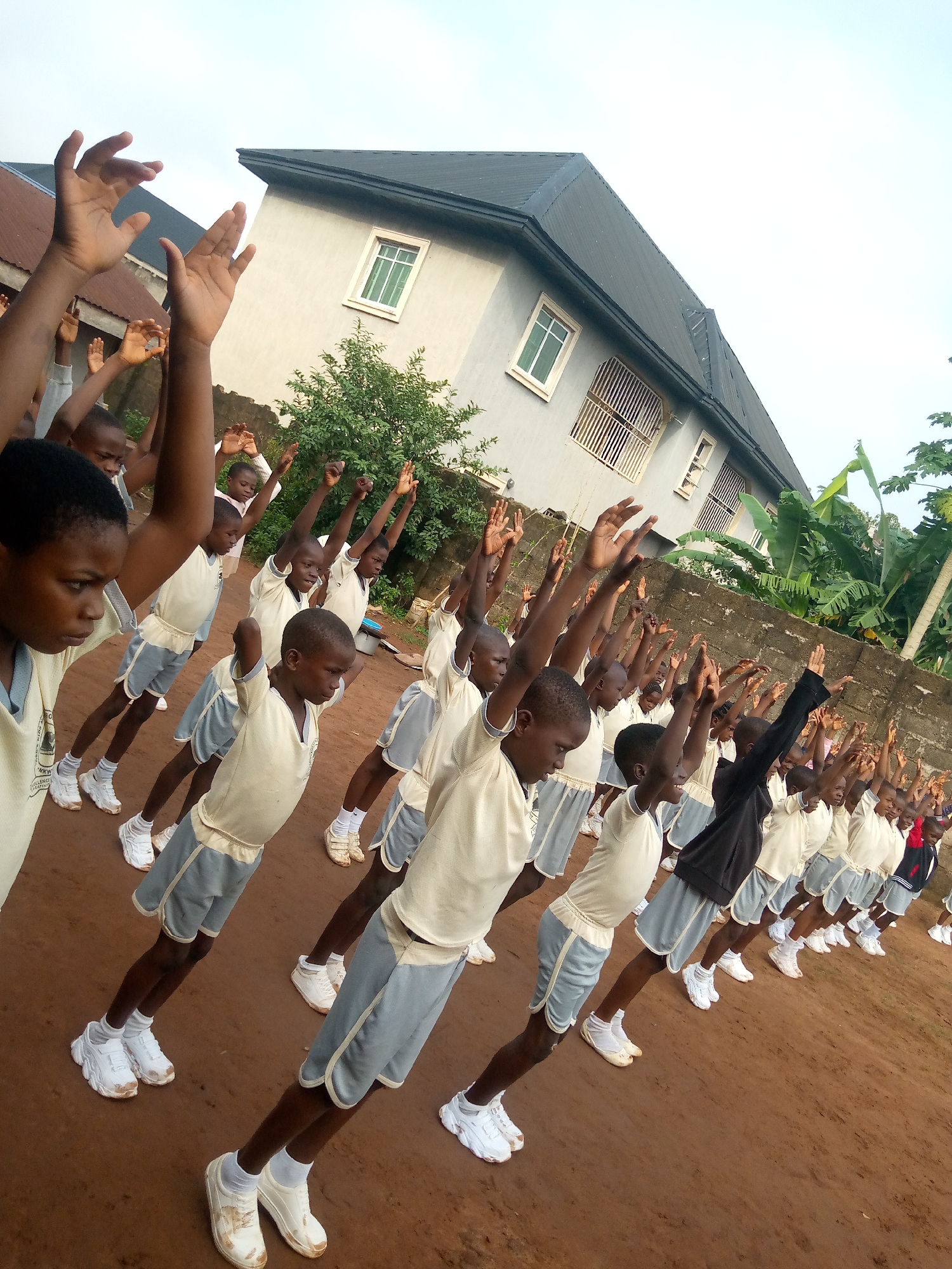Students drill and exercise outdoors at a Nigerian schoolyard