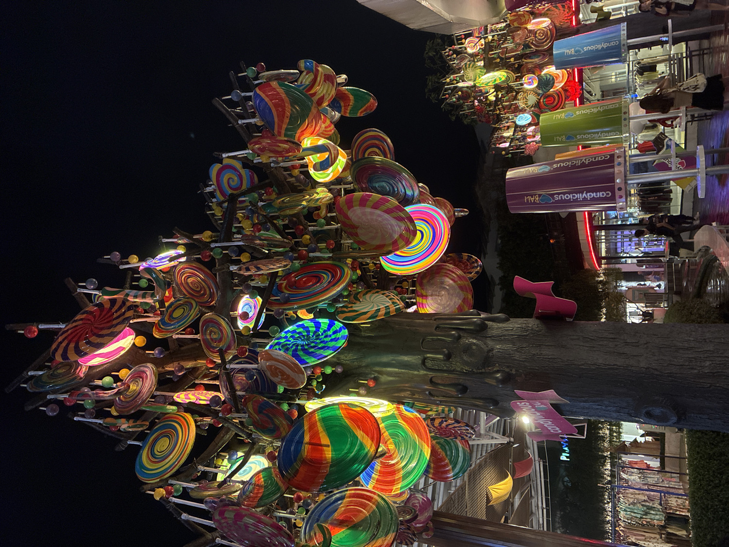 Candy store and illuminated tree sculpture documented in Kuta
