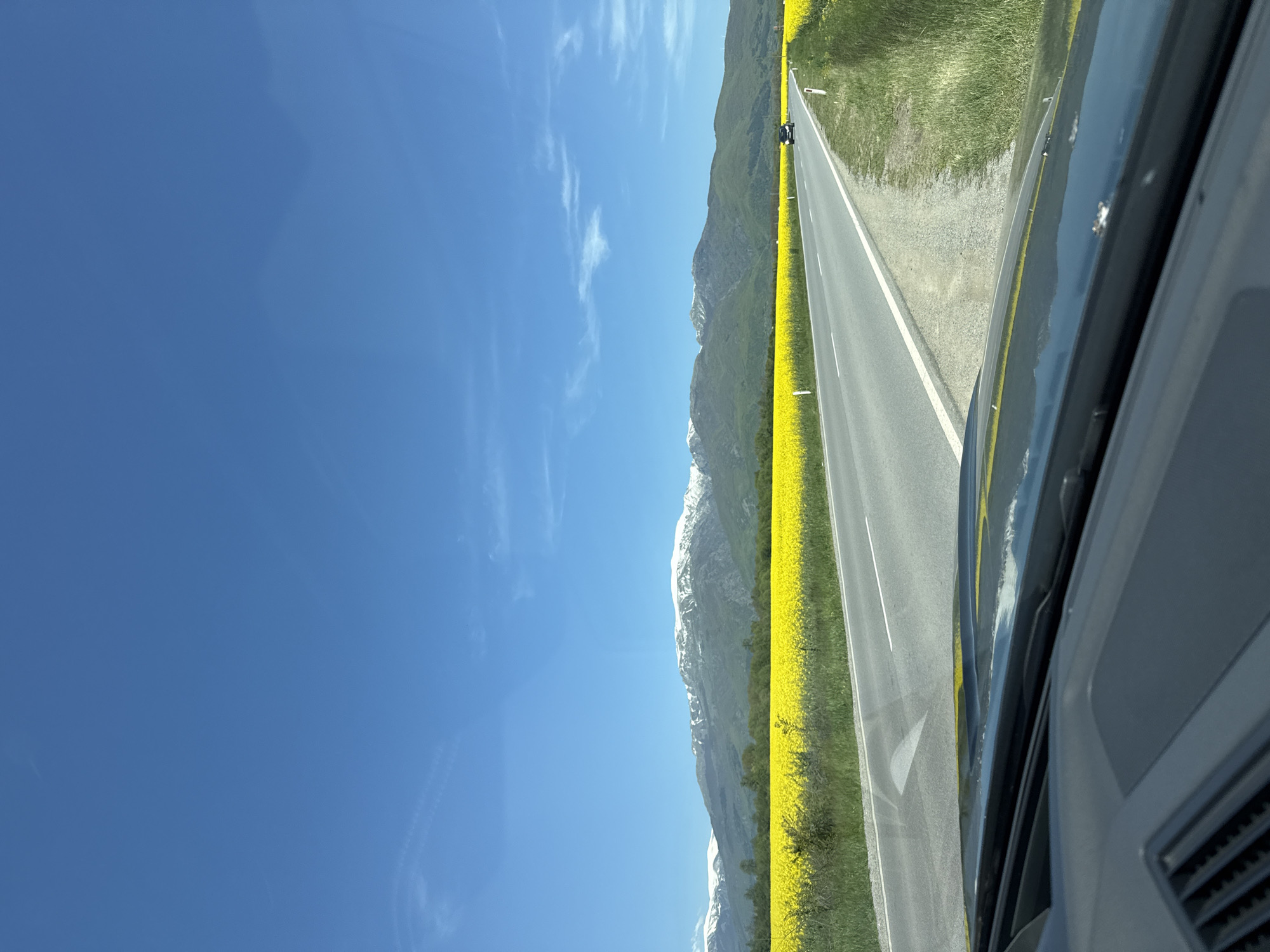 Rural mountain drive through yellow flower fields documented