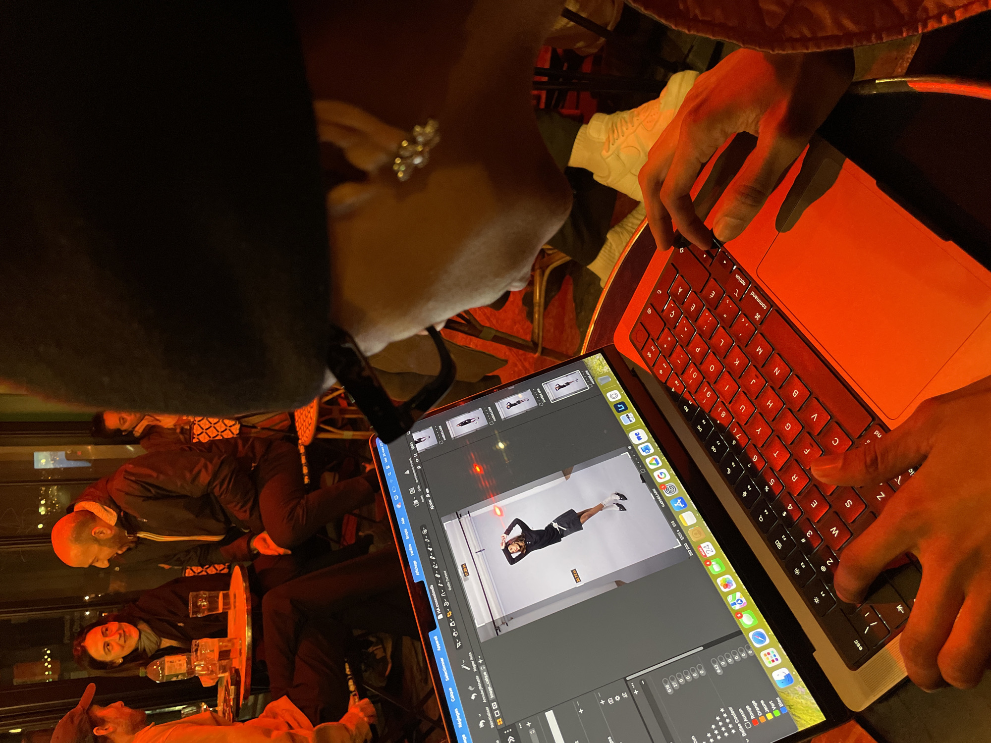 Person uses red-backlit MacBook laptop in Paris