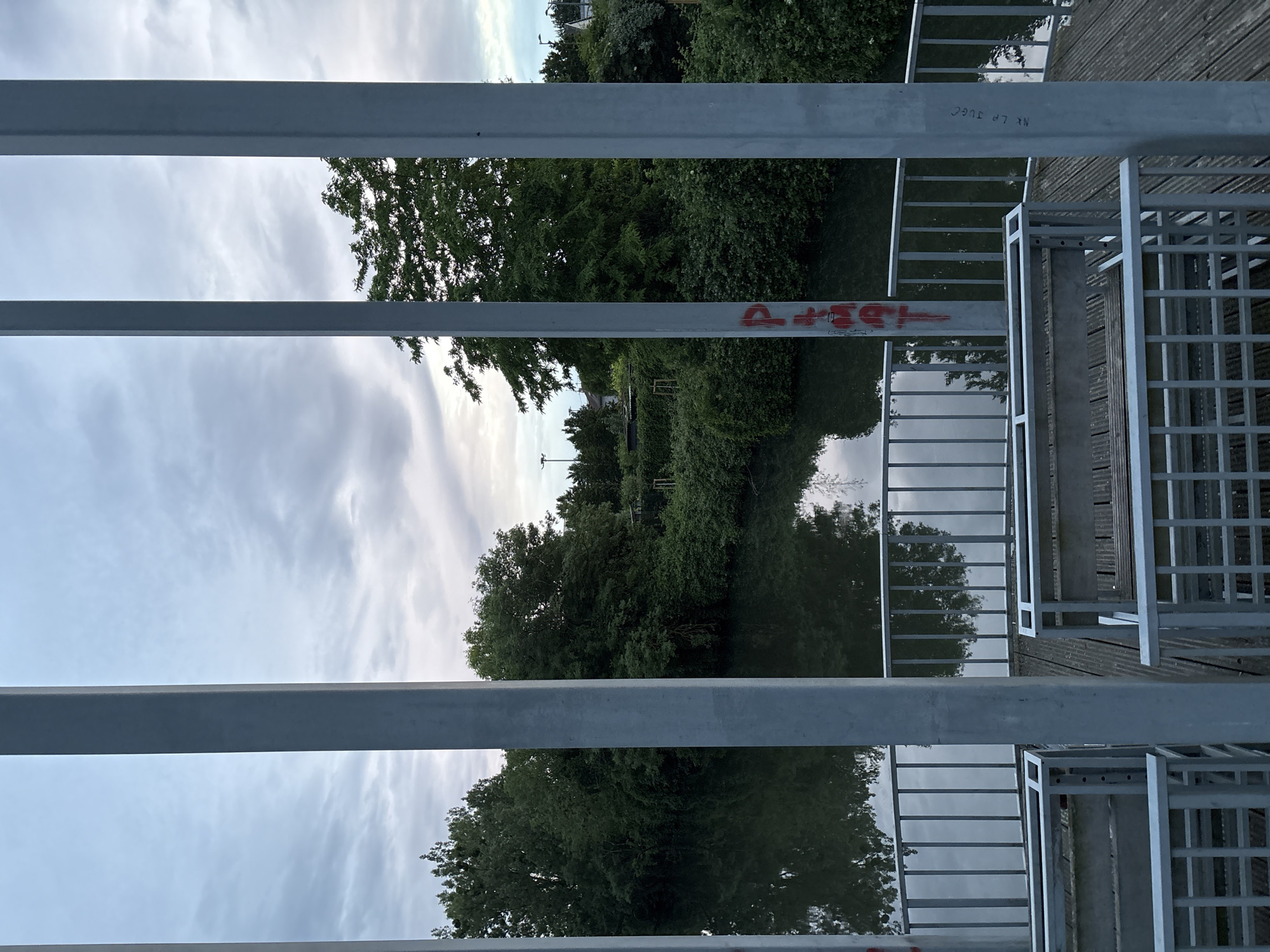 Bridge walker documents waterway reflections during evening stroll
