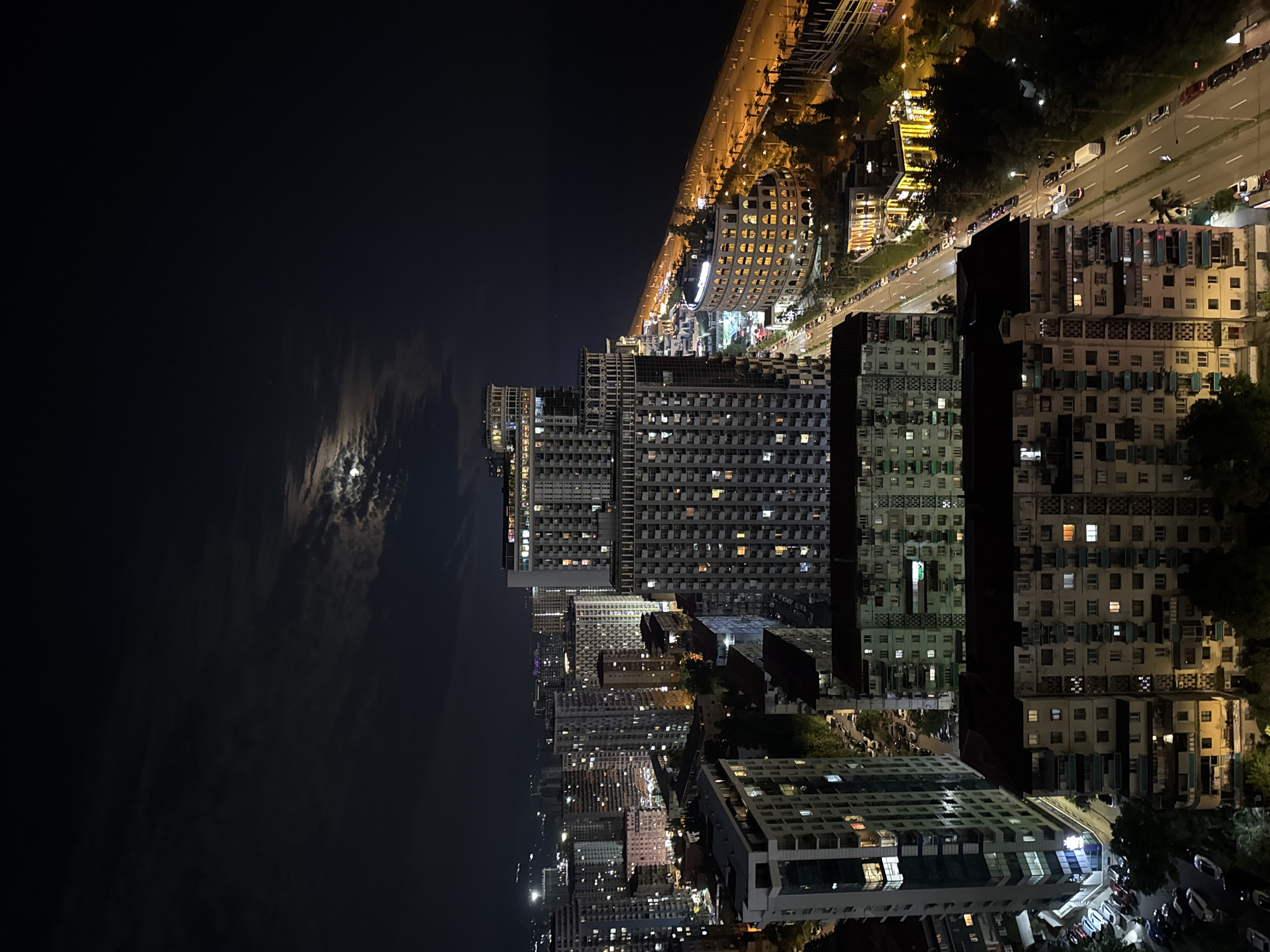 Batumi's nighttime skyline from above, coastal city lit up