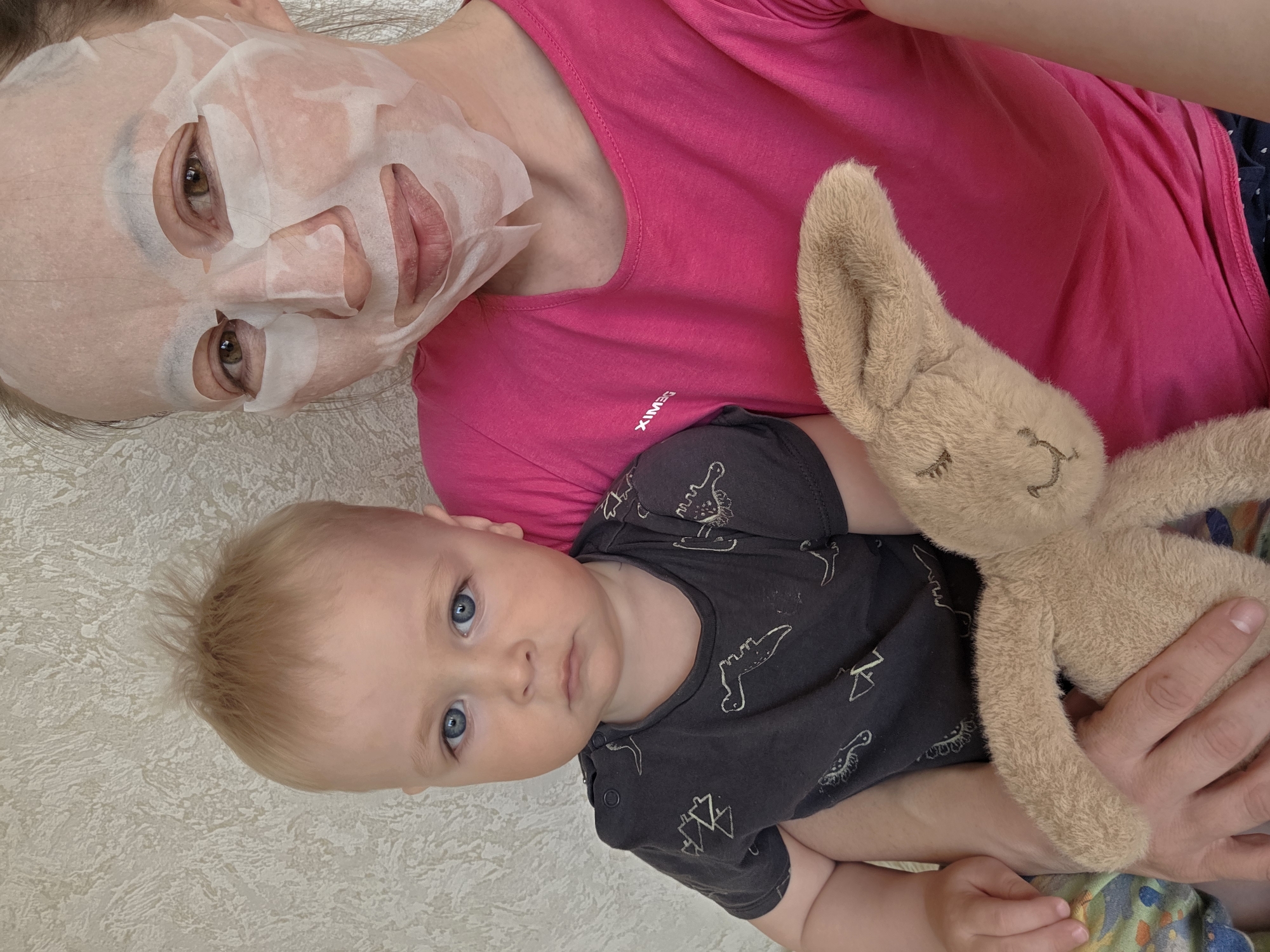 Woman in face mask lies with baby in Chaikovsky