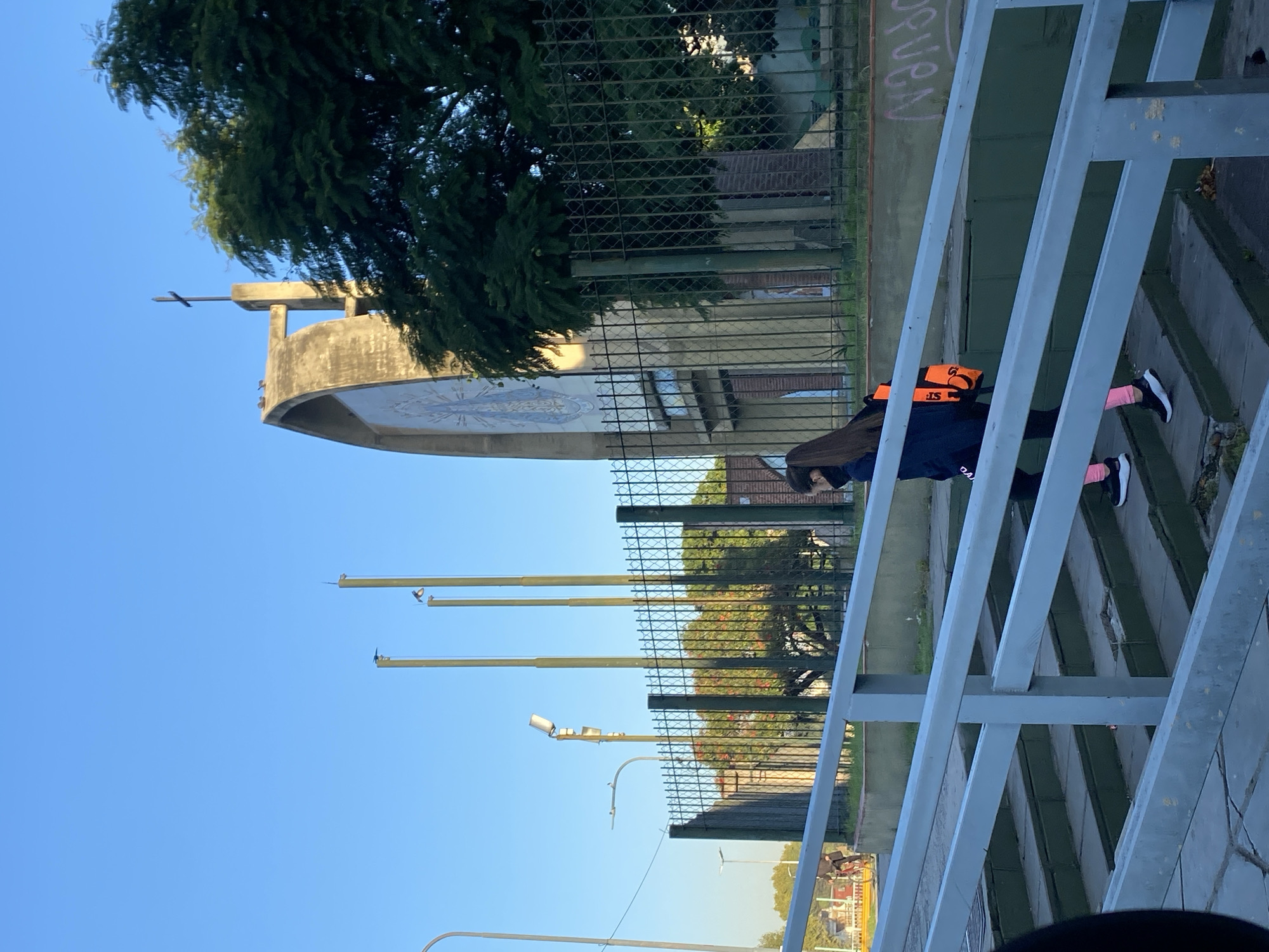 Pedestrian walks past fenced religious building in Buenos Aires