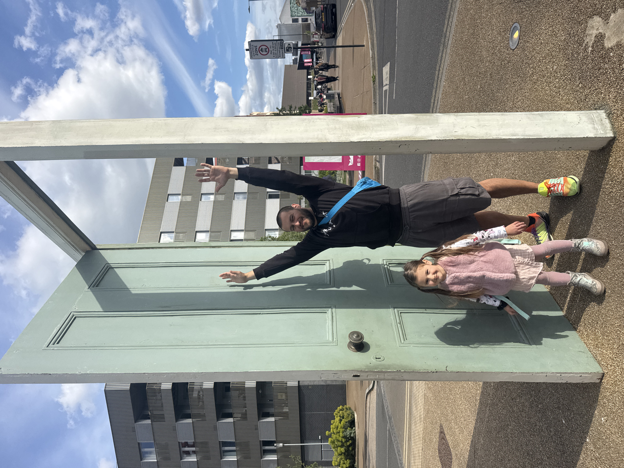 Street art installation features floating figures through doorframe in London