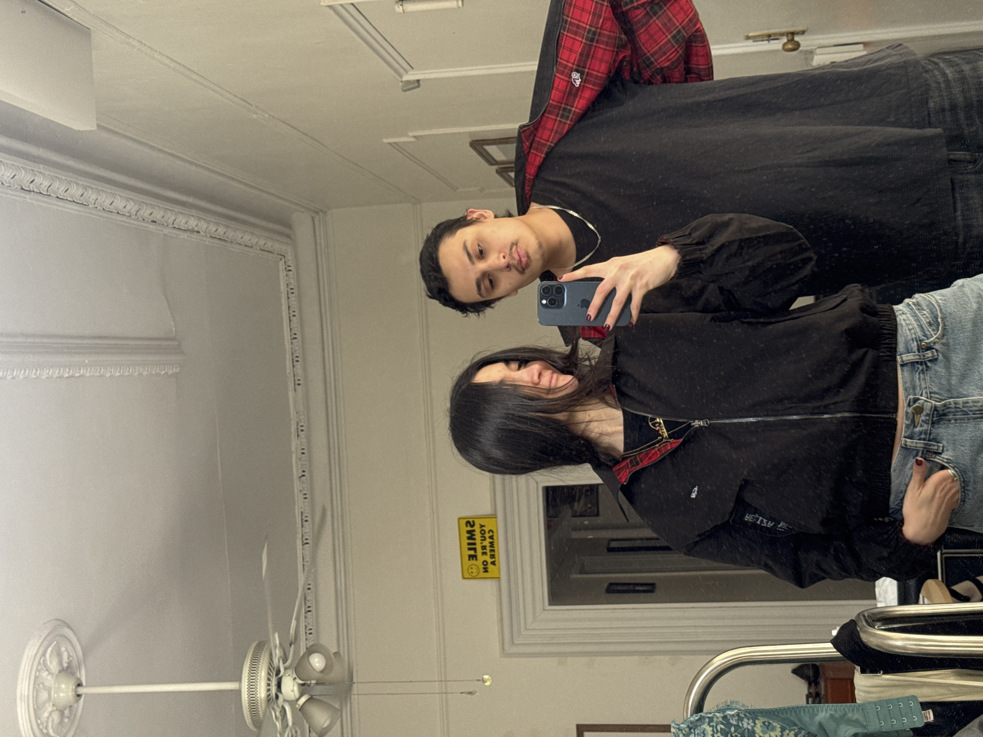 Two people take mirror selfie in New York room