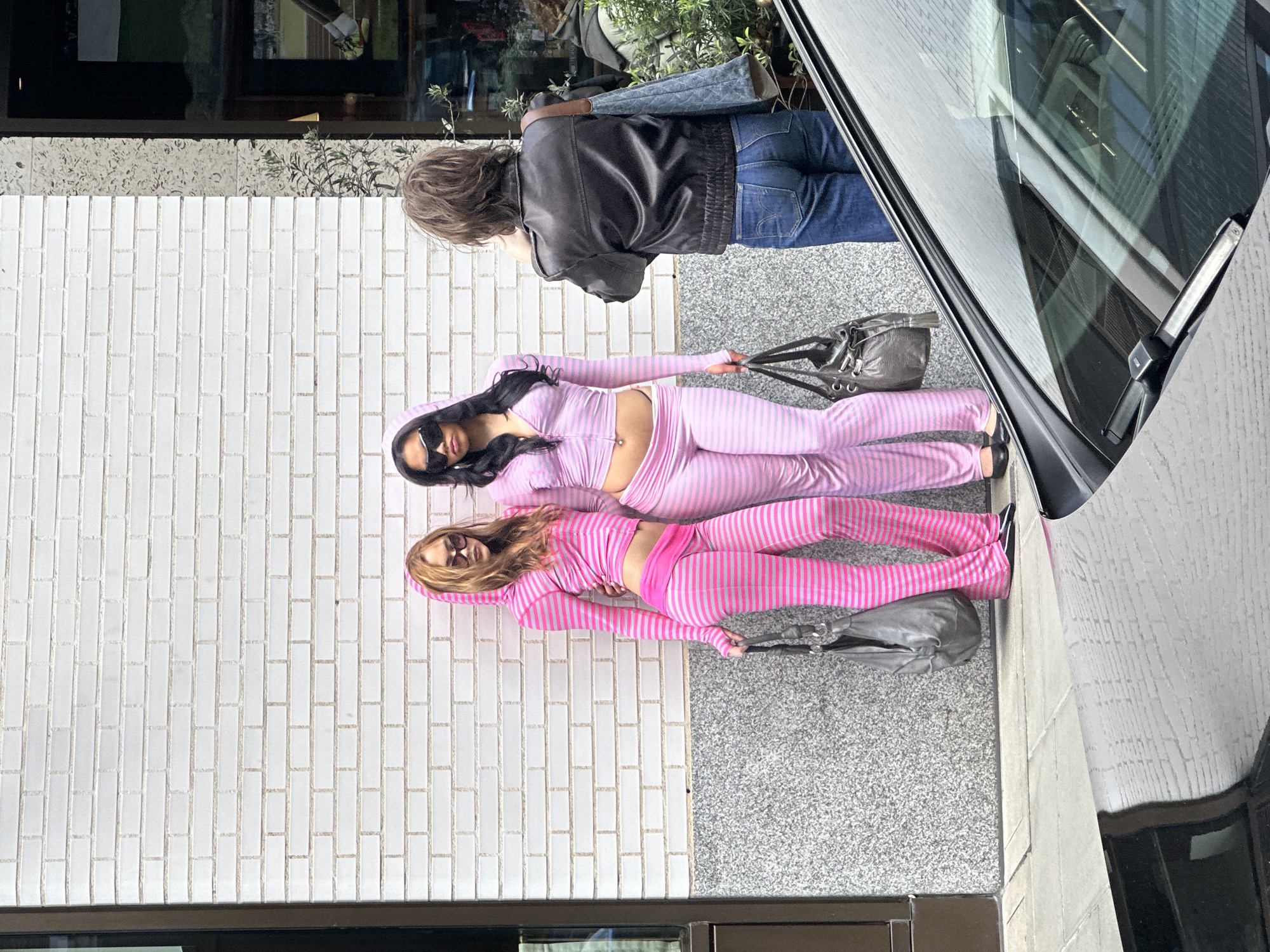 Two women in matching tracksuits lie on London pavement