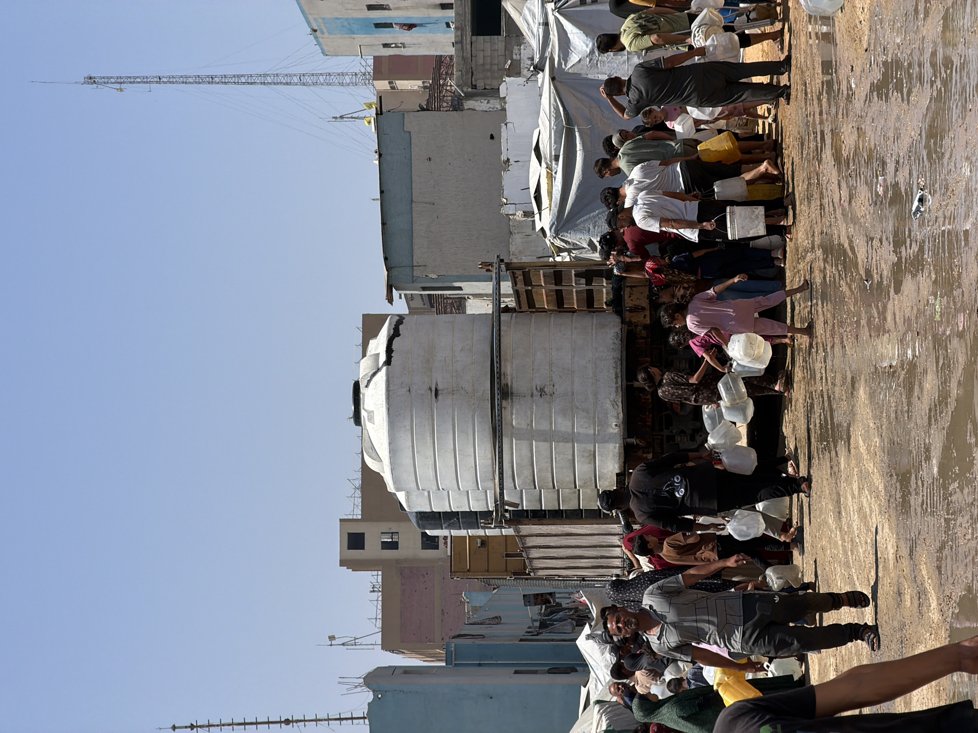 Families collect water from trucks in Gaza City
