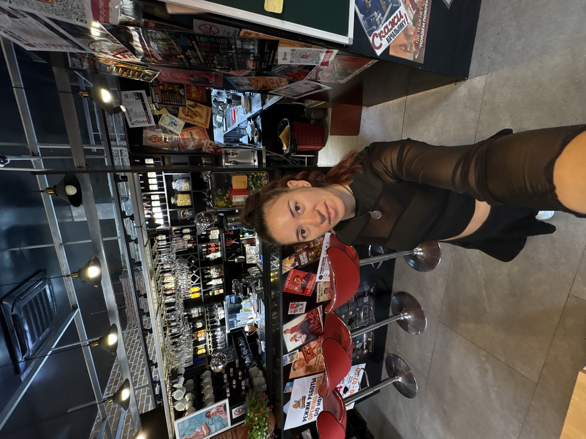 Selfies at a bar, shelves of bottles in the background