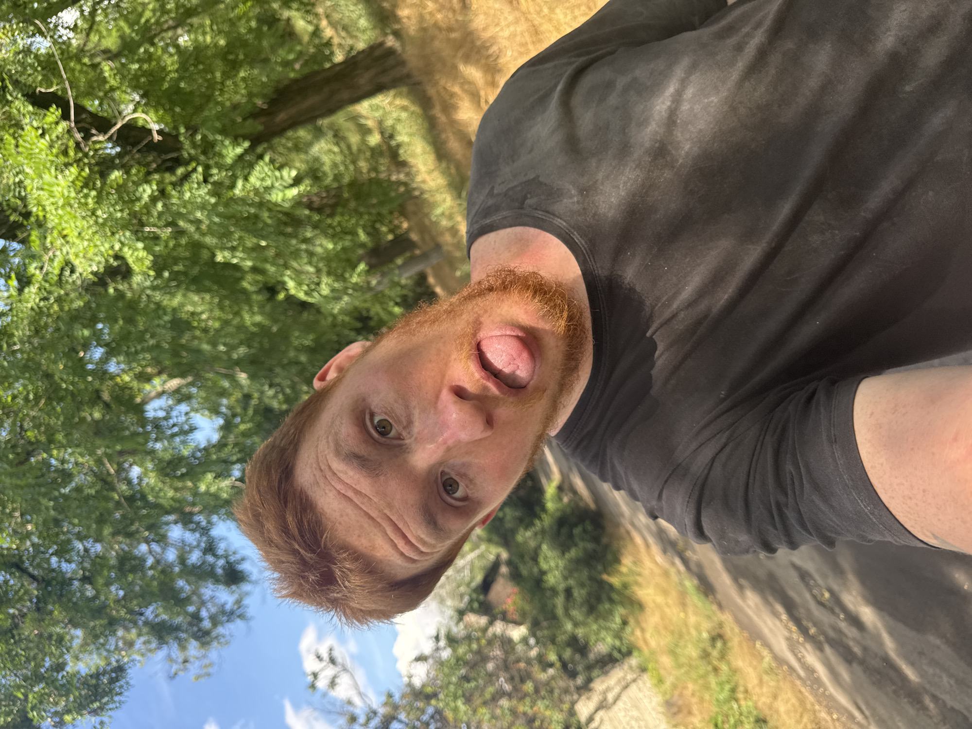 Outdoor selfie session on a gravel road with tattoos and greenery