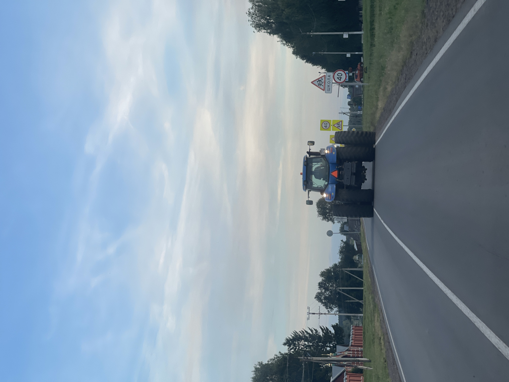 Tractor passes Orthodox church on a quiet Russian village road