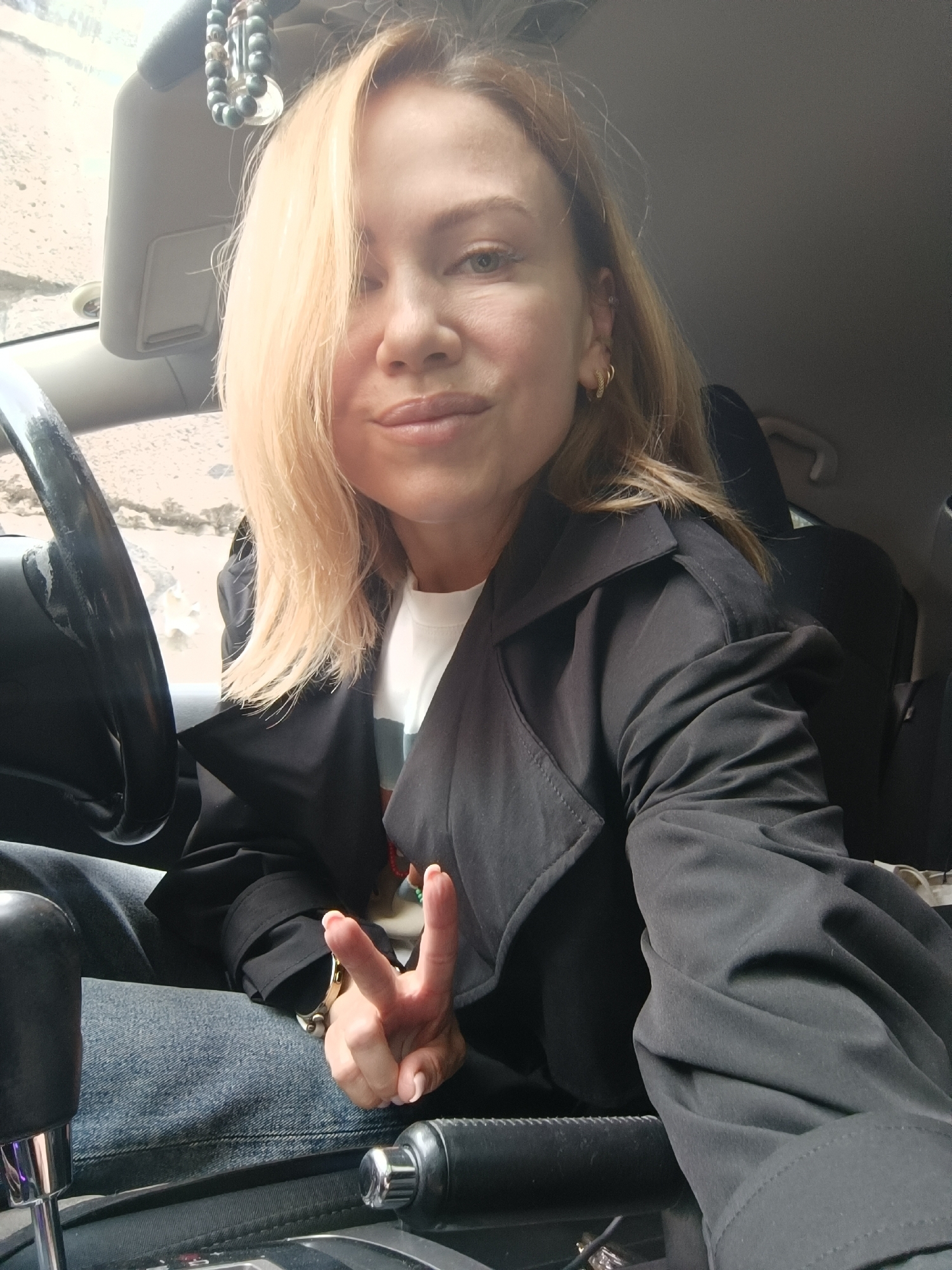 Woman takes selfie in car driver's seat, Naberezhnye Chelny