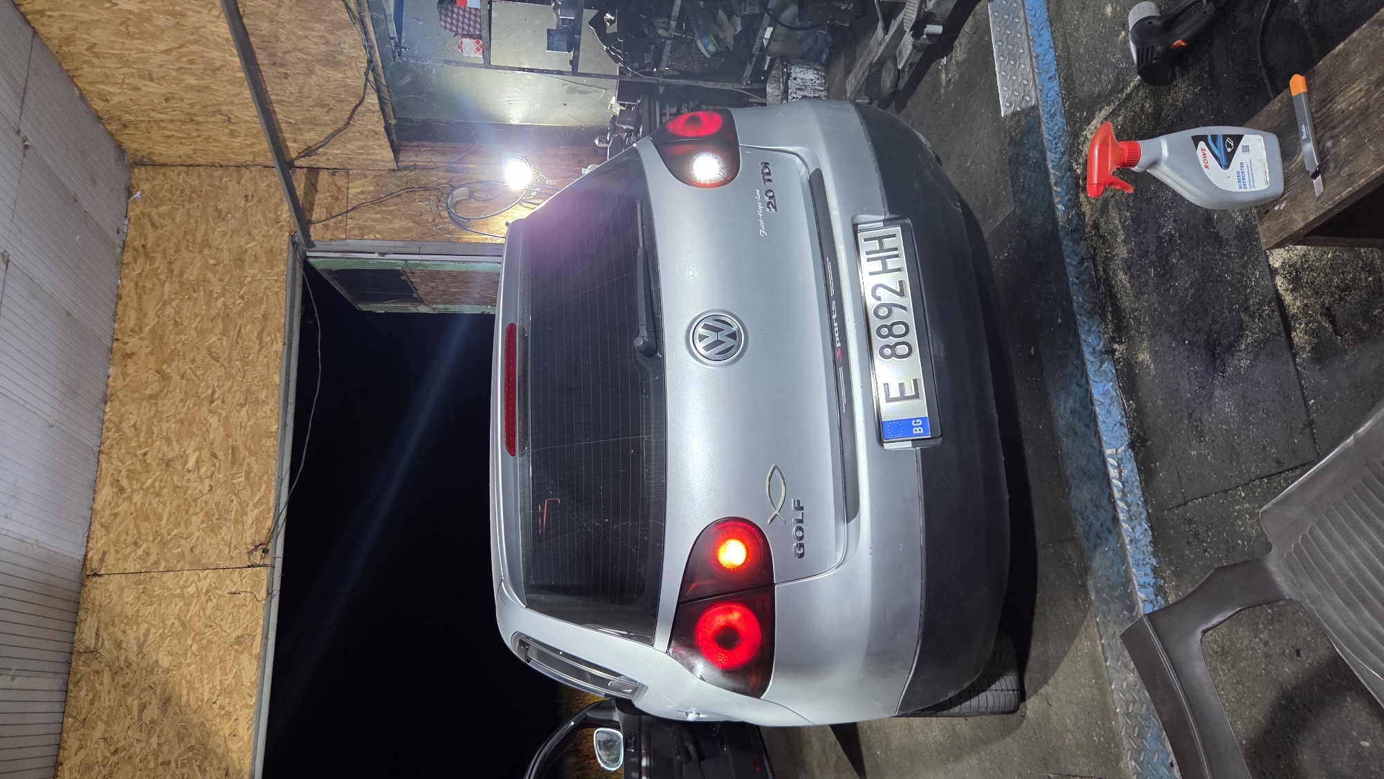 Silver VW Golf parked indoors, brake lights on